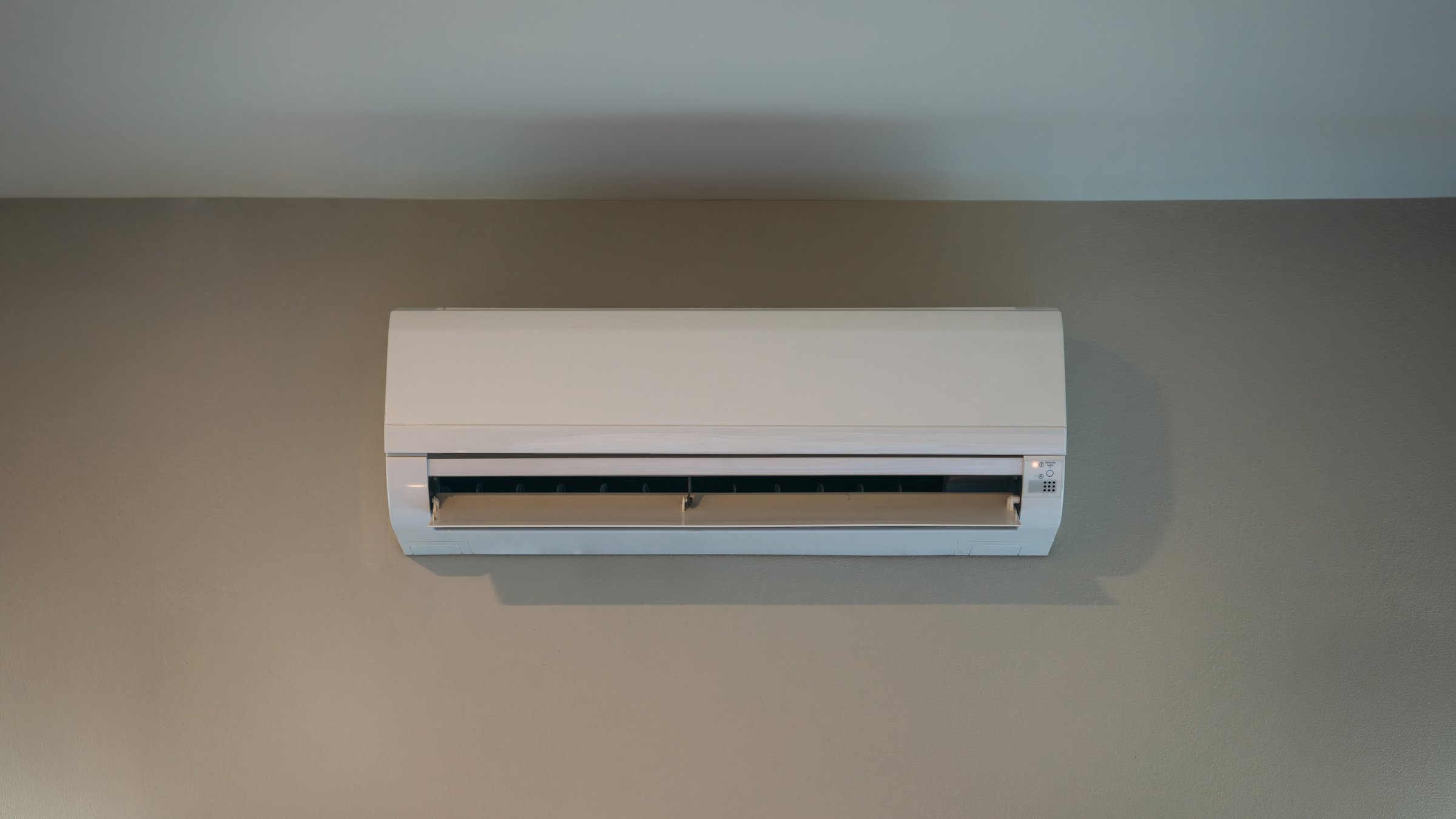 Air conditioner on a white wall, perfect for cooling during hot summers.