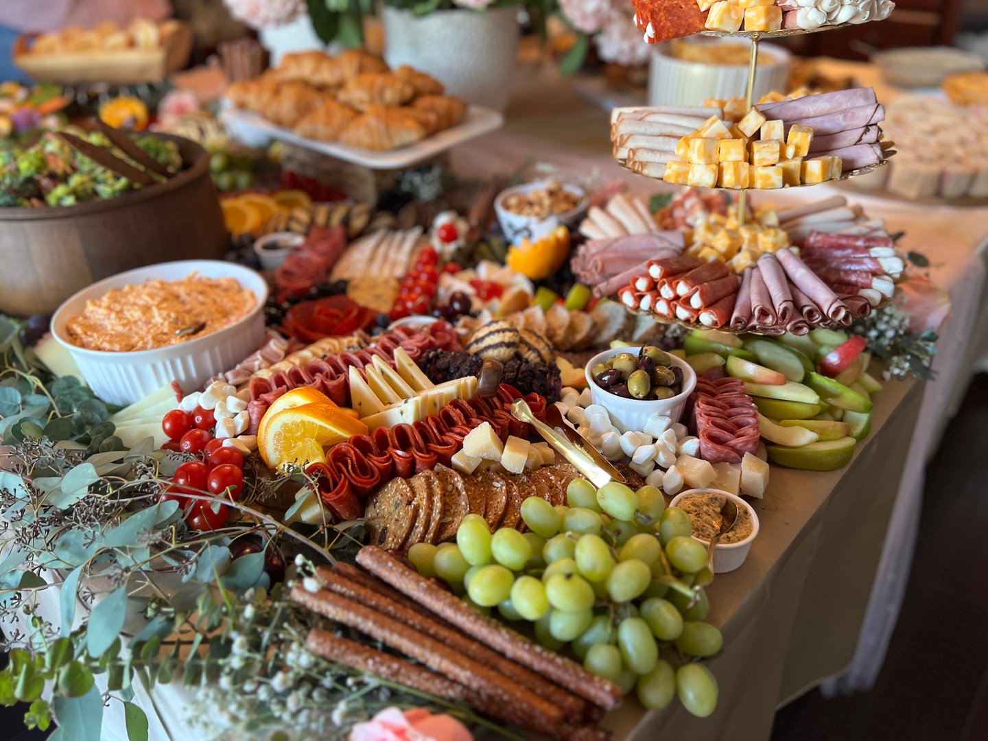 Colorful array of charcuterie, cheeses, fruits, breads and more foods  prepared for a festive gathering