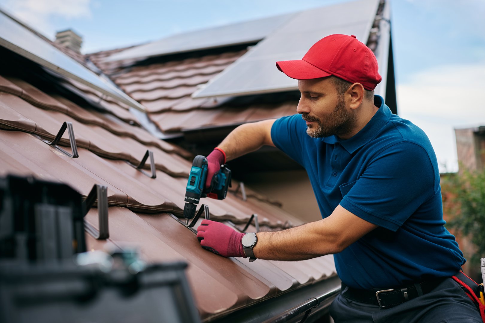Roofer fixing tiles on house roof