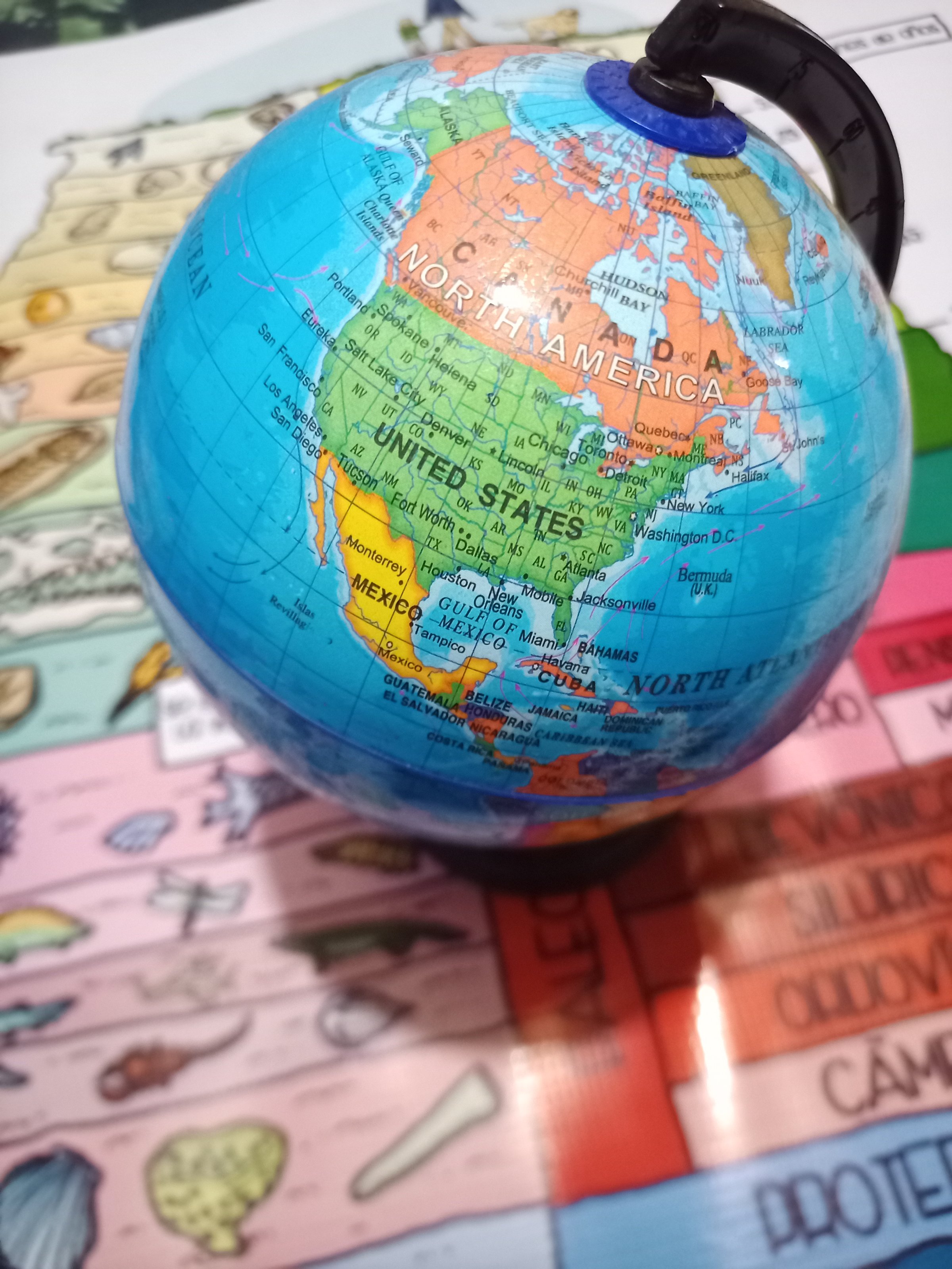 A small globe showing North America, Mexico, and part of South America, with colorful map illustrations in the background.