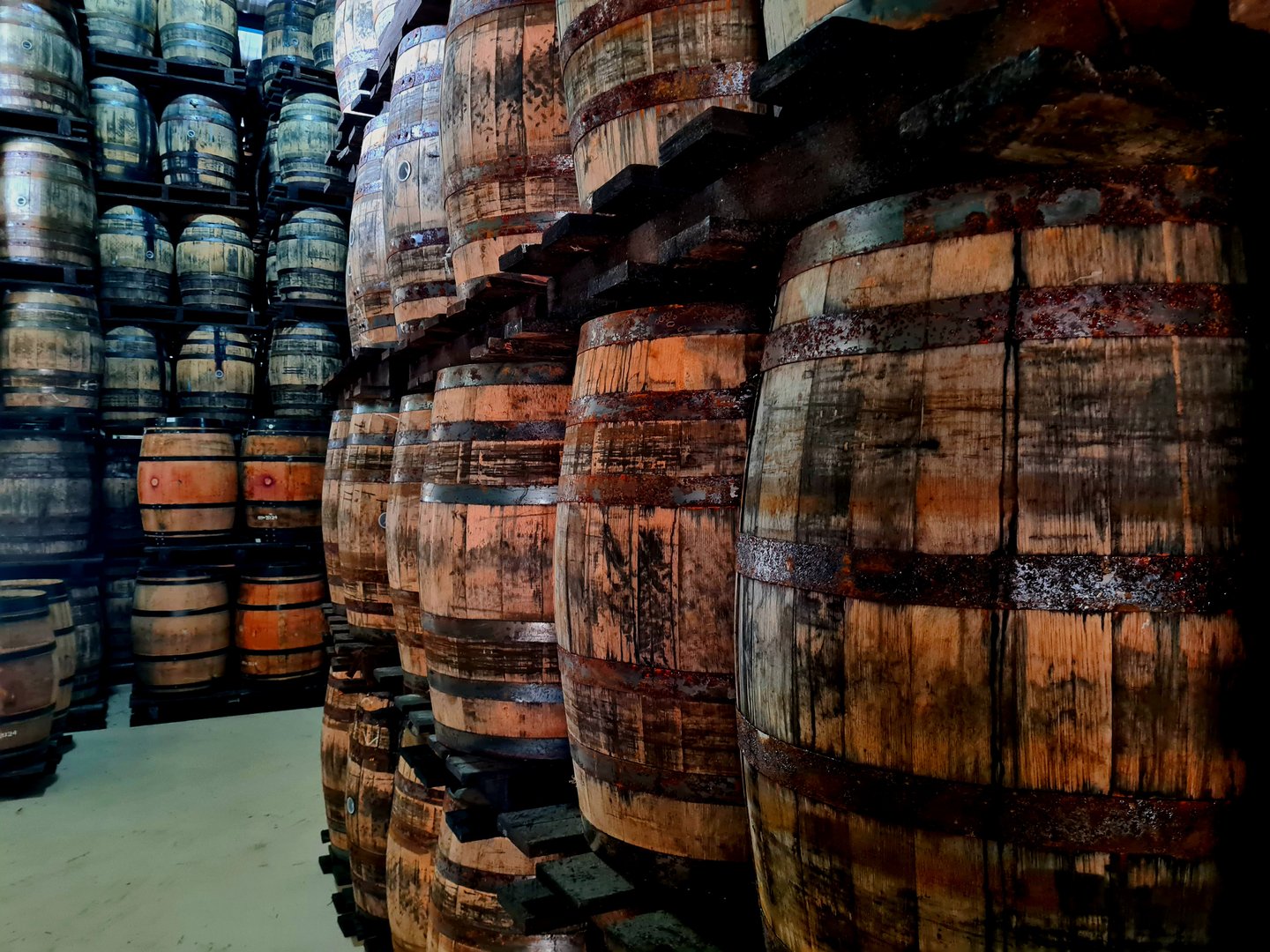 An alley of high stacks of old rum barrels placed on top of each other for letting the rum age.