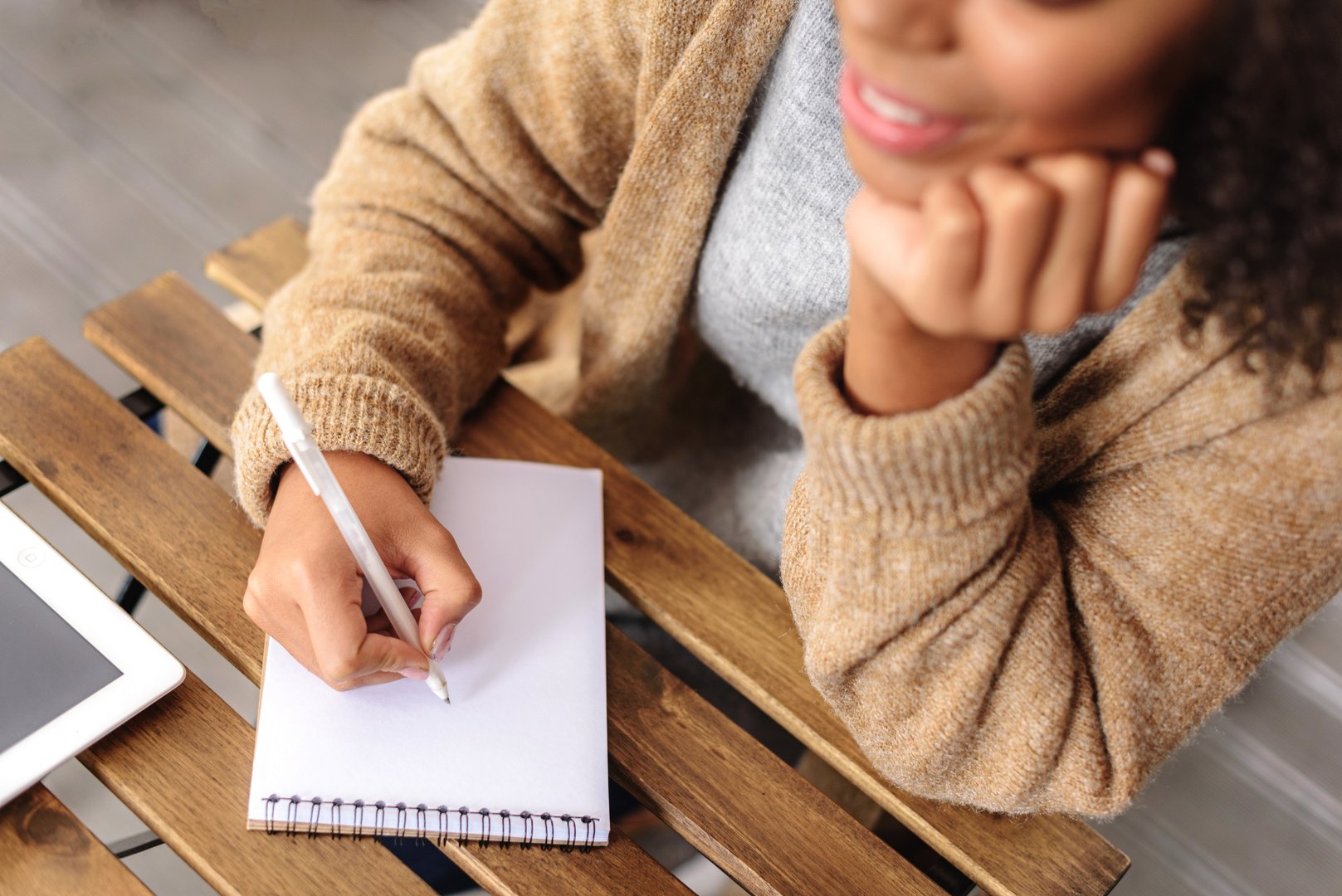 hand of a woman drawing in a jotter on the table, selective focus