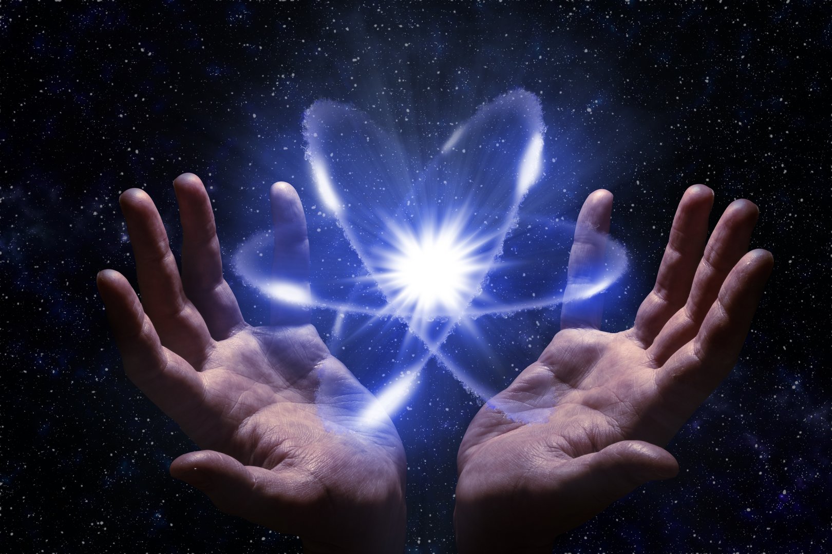 Radiant atom molecule symbol in hands on dark cosmic background