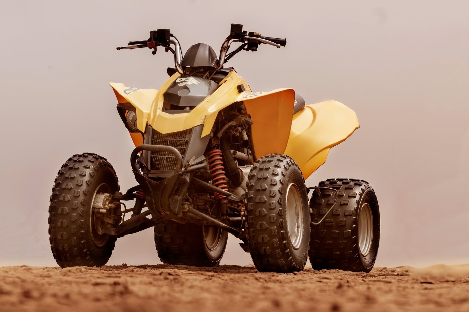 Walvis Bay, Namibia -26 January, 2022:  
 Bottom view of modern yellow all-terrain vehicle standing in desert on cloudy day
