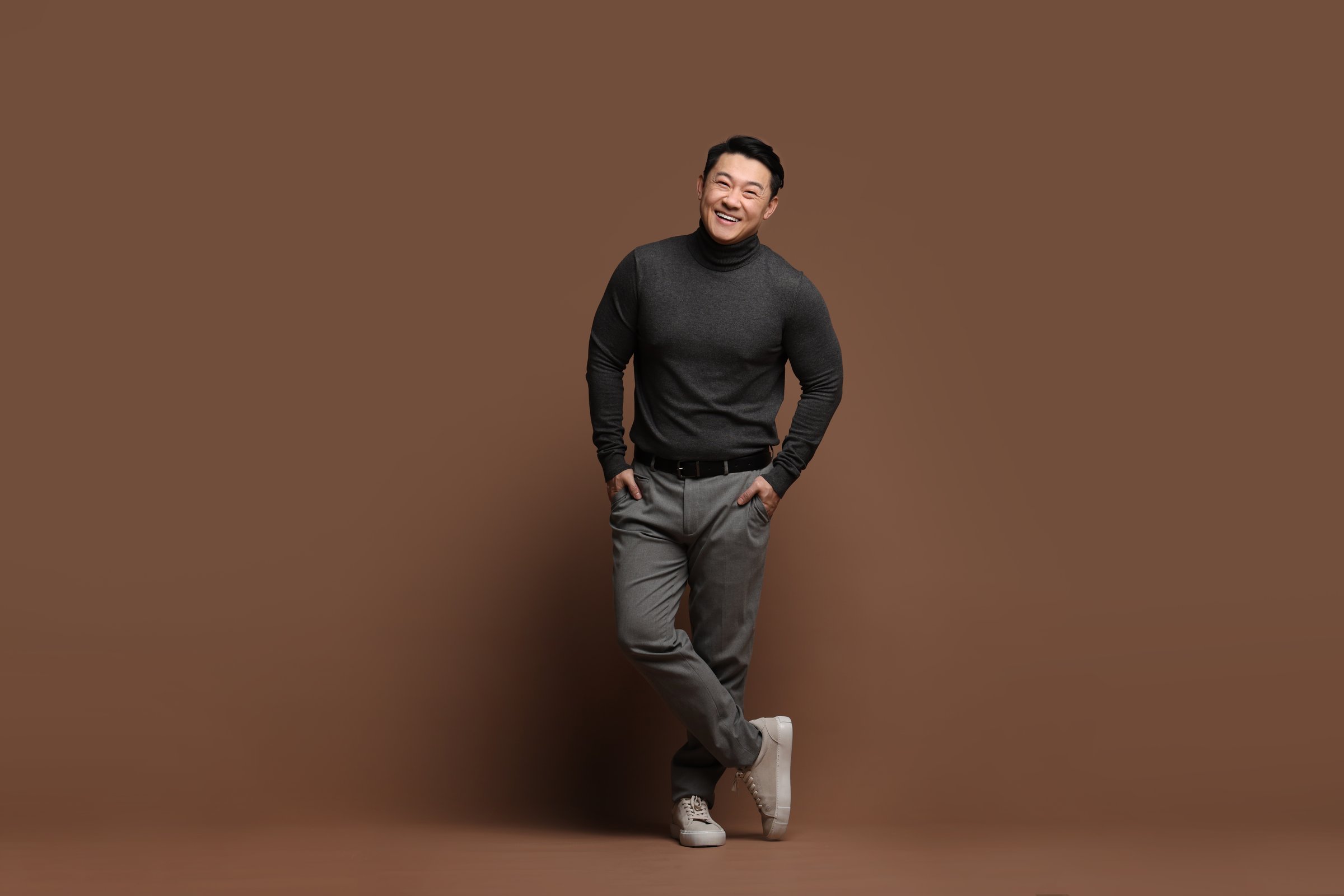 Full length portrait of happy man on brown background