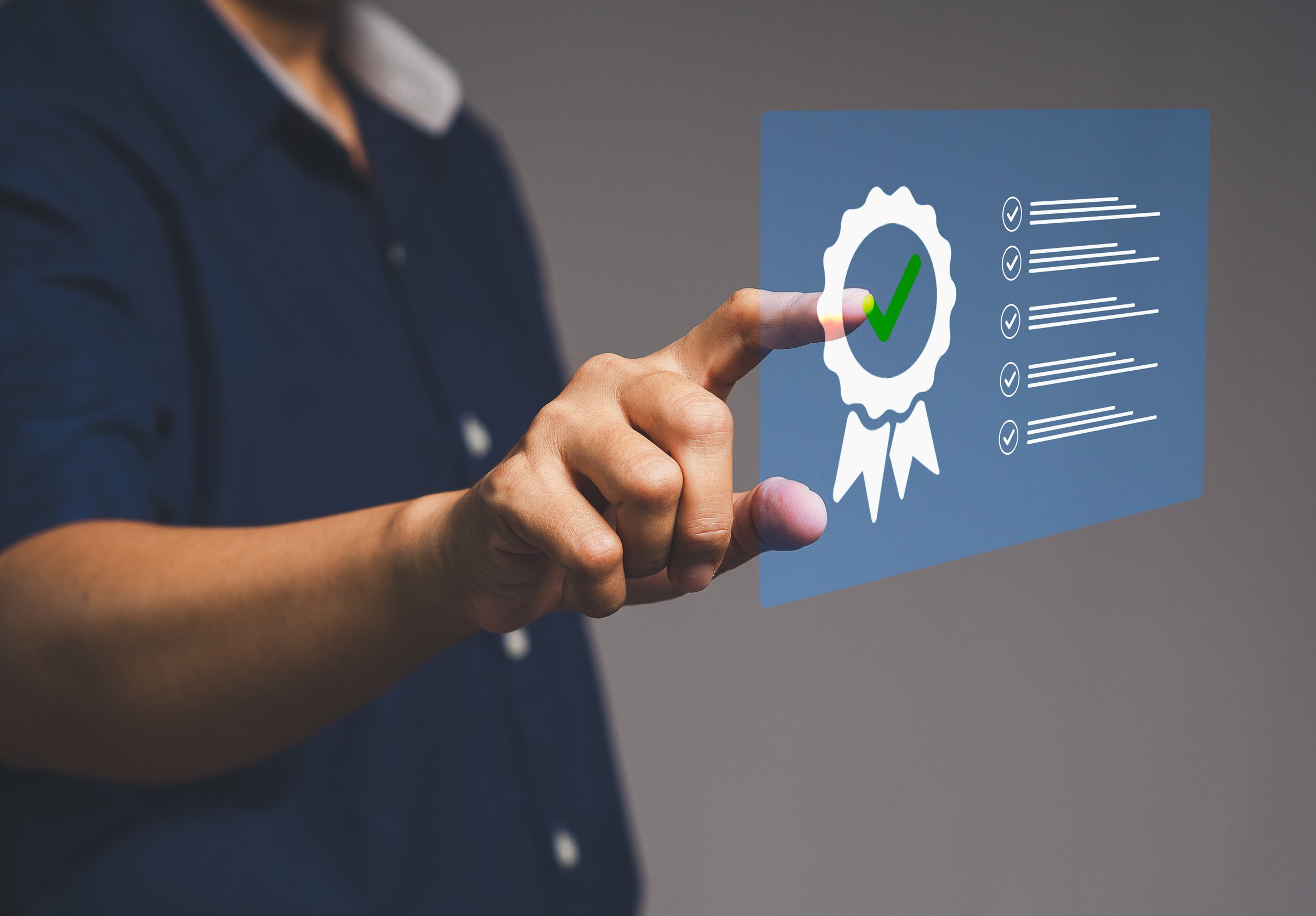 Hand touching holographic quality certification icon with checklist for business compliance concept.