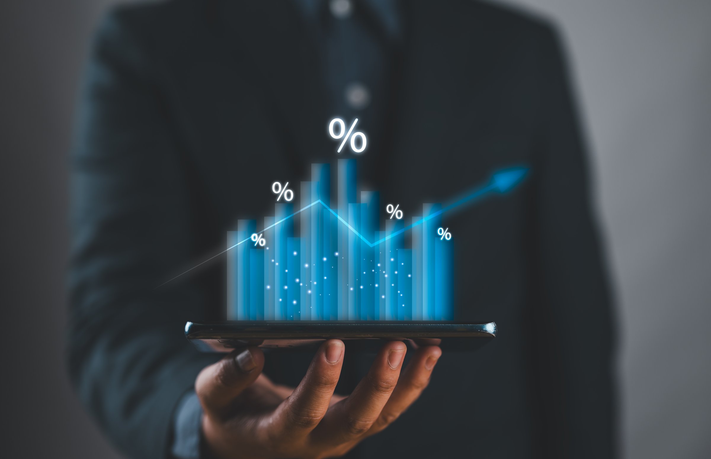 Businessman holding growth graph with percent symbol for increase in interest rates and dividends, return on stocks and mutual funds, long term Investments for retirement