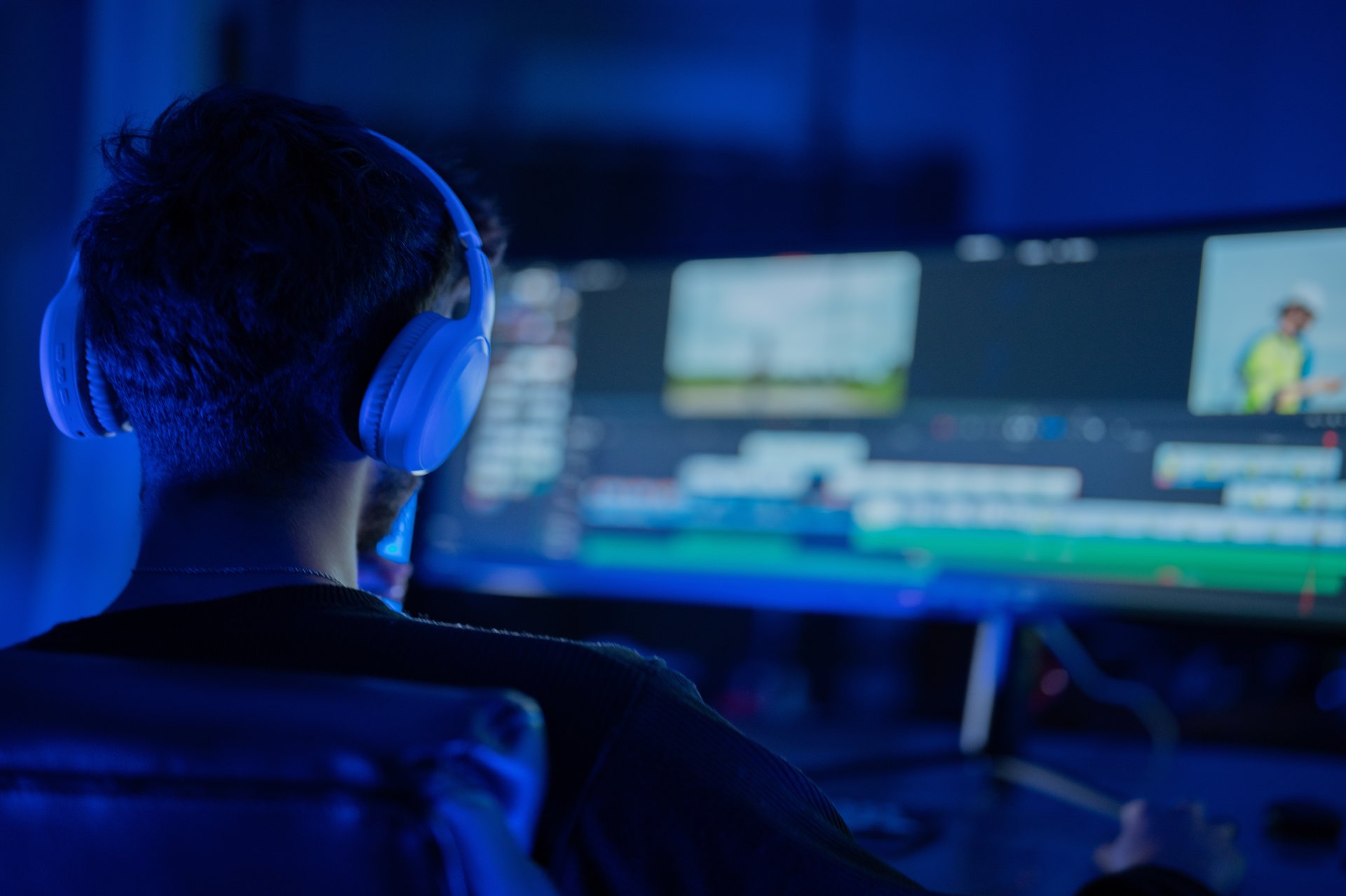 Video editor working in dimly lit room