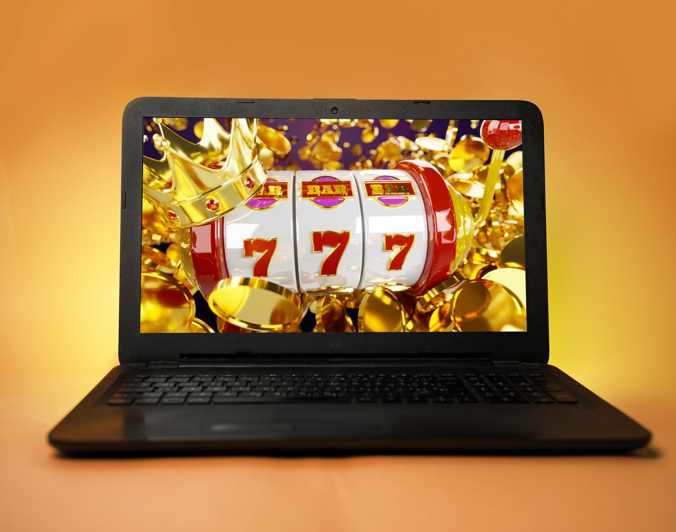 Laptop on orange yellow background, casino winnings concept, 777 and bunch of coins flying on the screen