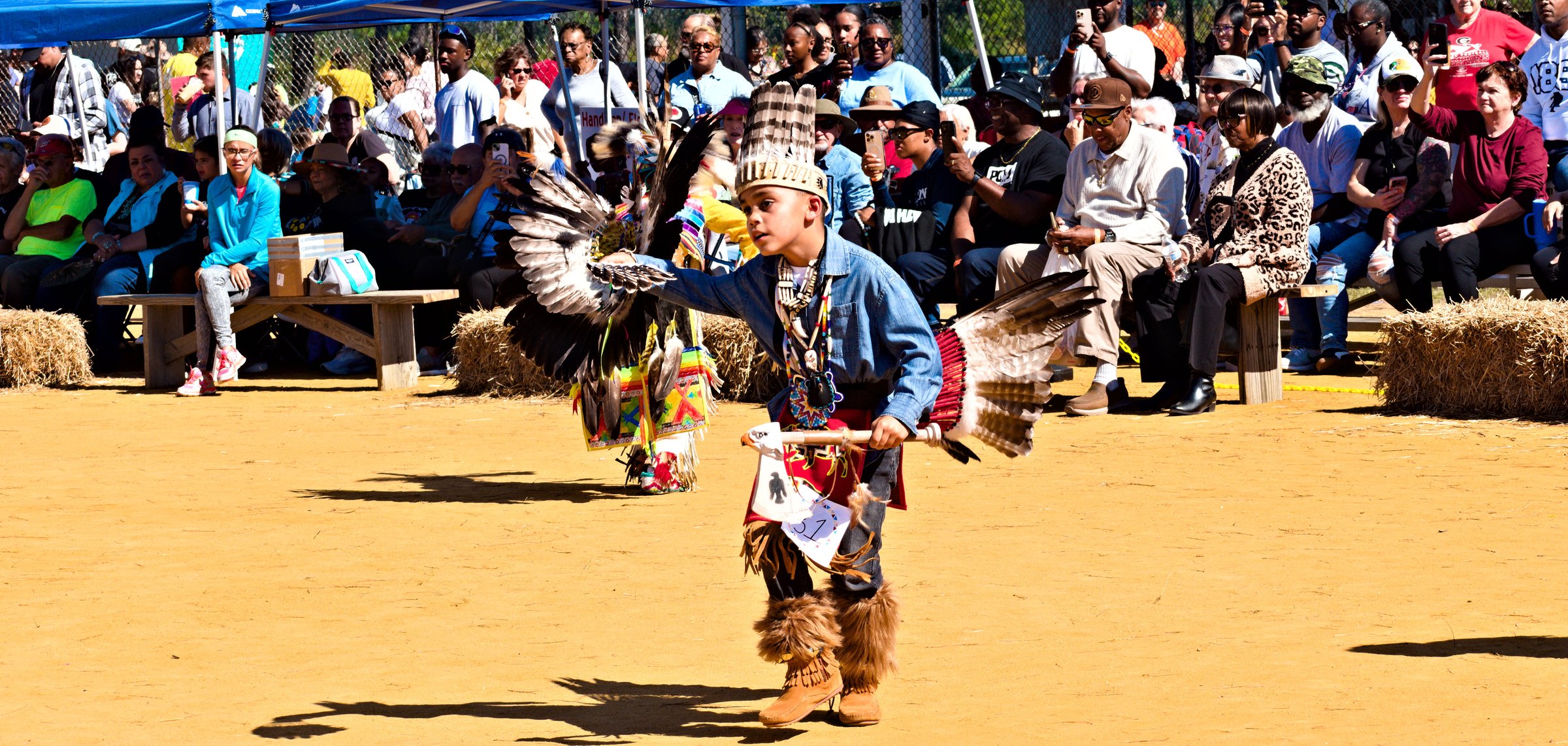 Bolton, NC  October 18, 2025: A young Native American boy in traditional regalia dances at the 2025 Waccamaw Siouan Pow Wow in a celebration of native culture and heritage.