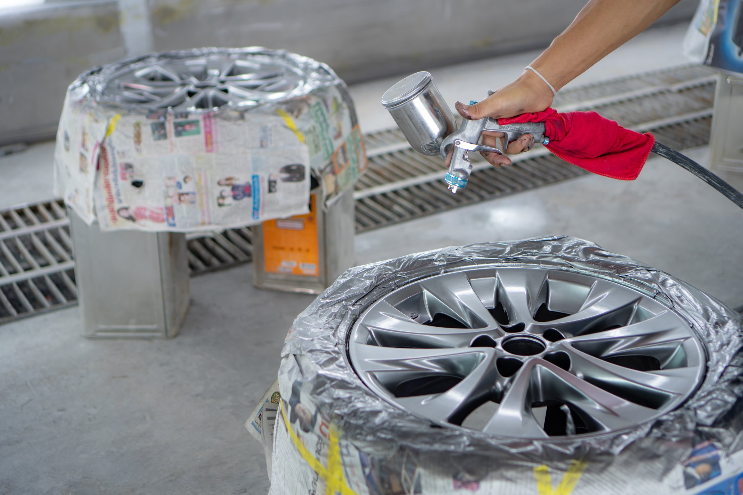 Automobile disc restoring. Painter painting light alloy wheel with spray