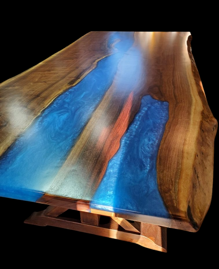 Wooden table with blue resin river design, featuring smooth, polished surface and natural edges, supported by wooden legs.