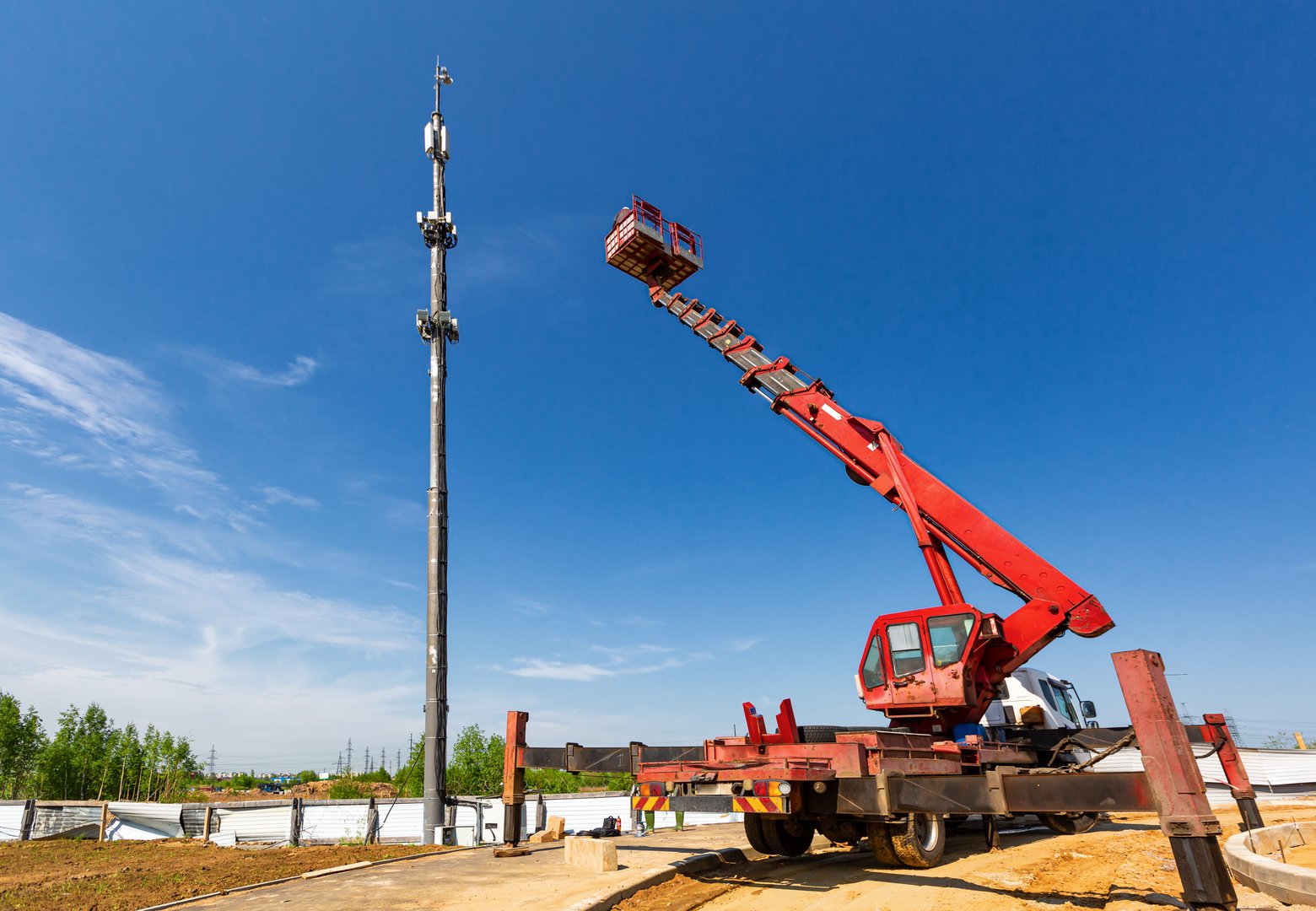 An aerial work platform, also known as an aerial device, elevating work platform, cherry picker, bucket truck, mobile elevating work platform maintenances the telecommunication tower - cellular phone repeater mast.
