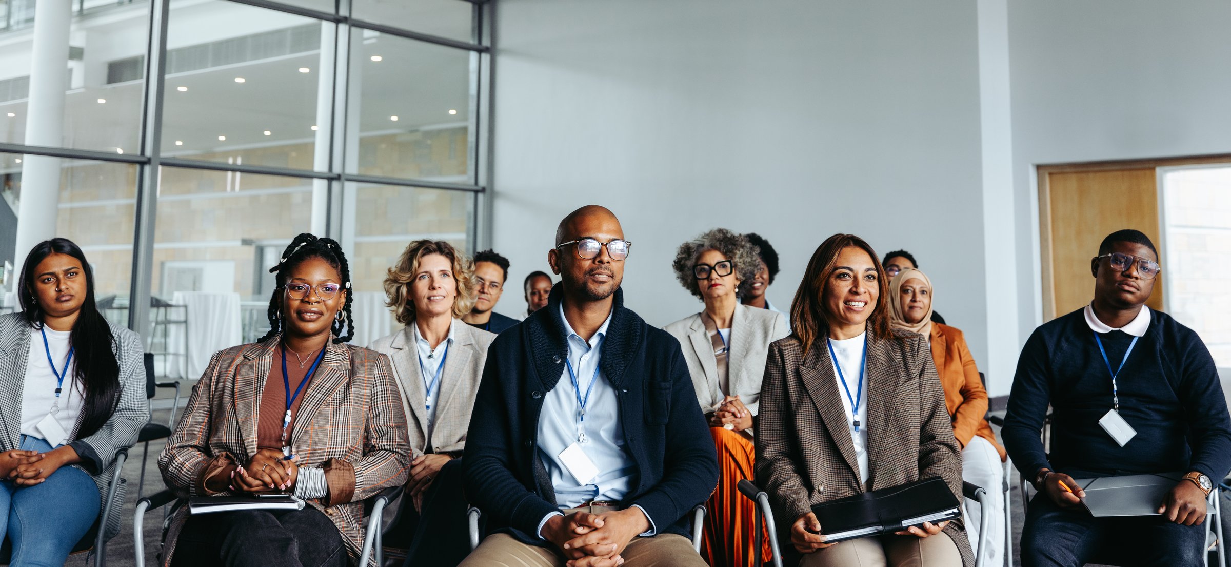 Diverse group of professionals engaged in a work conference, showcasing teamwork and collaboration in a modern office environment.