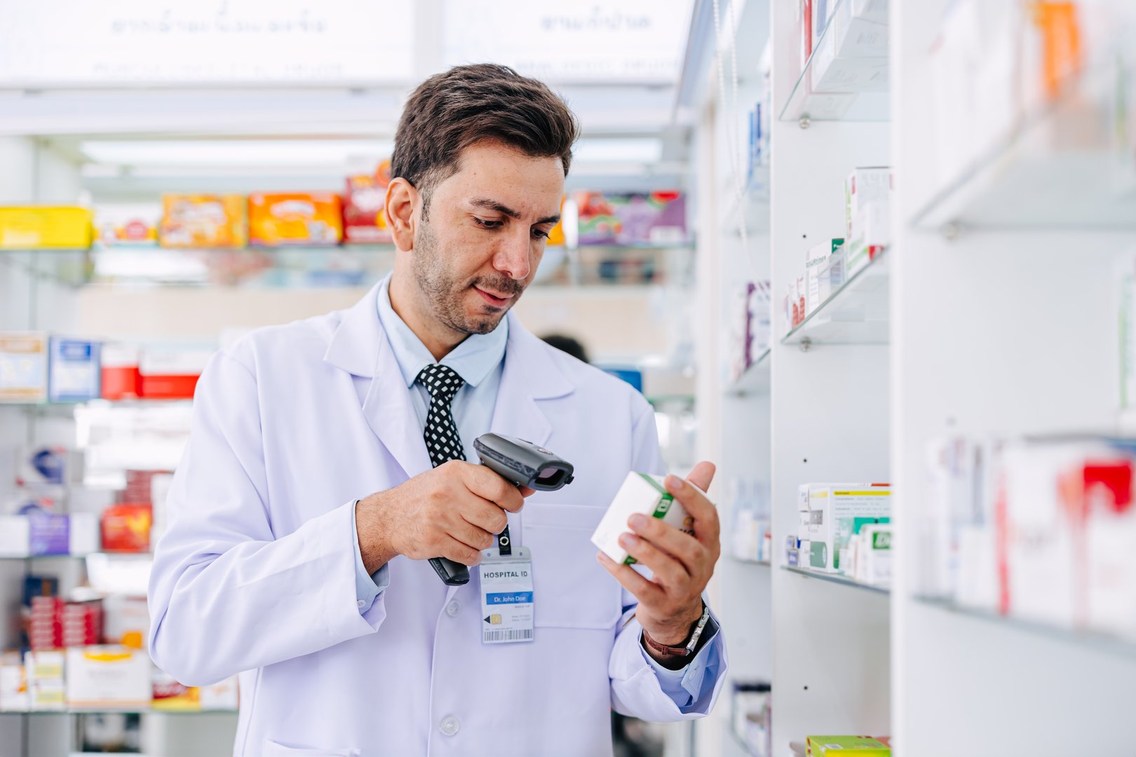 Pharmacist check stock inventory in Pharmacy medicine business. Drugstore employee in medicine shop scan barcode for warehouse drug expiration control.