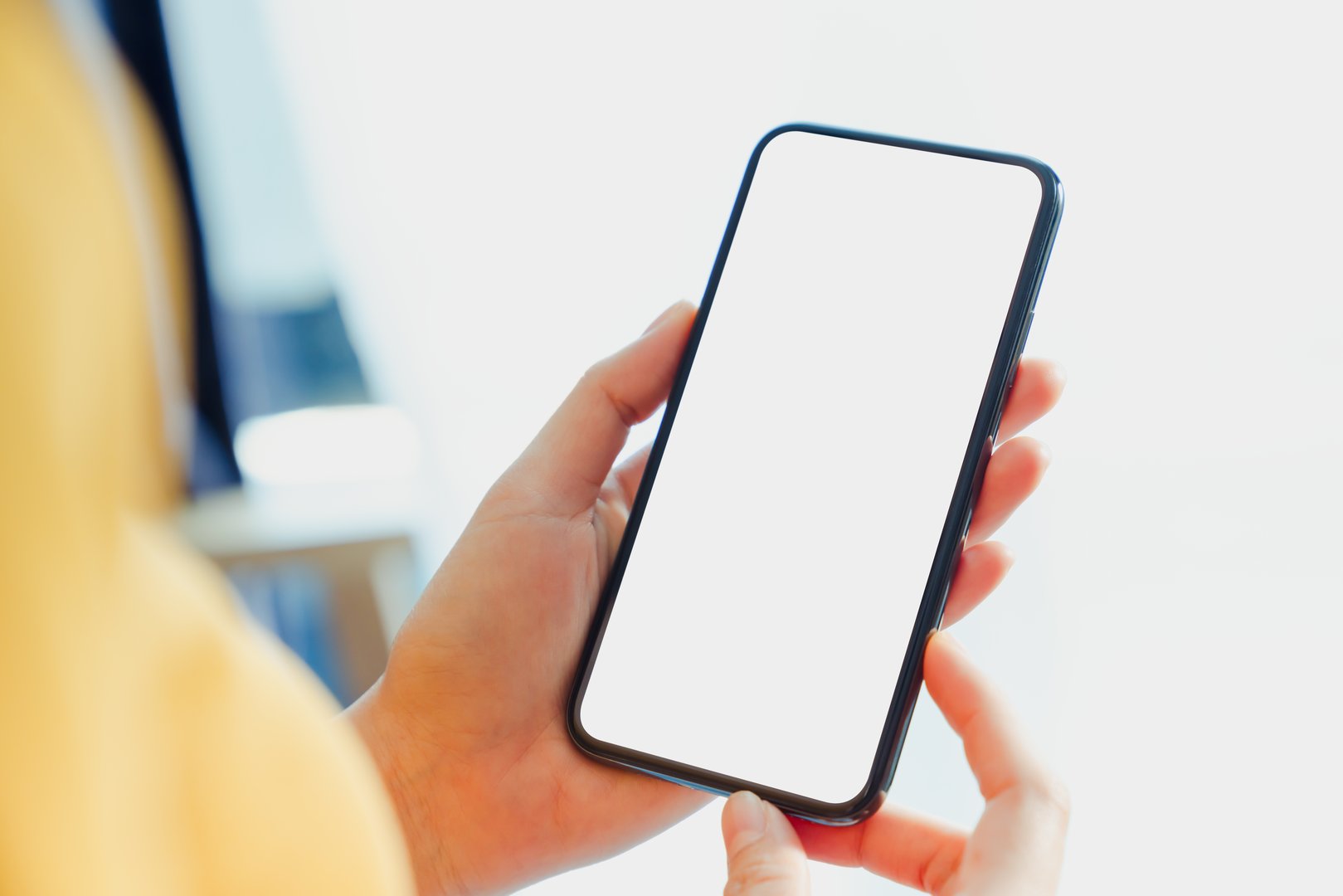 Hand holding smartphone mockup of blank screen, Take your screen to put on advertising.