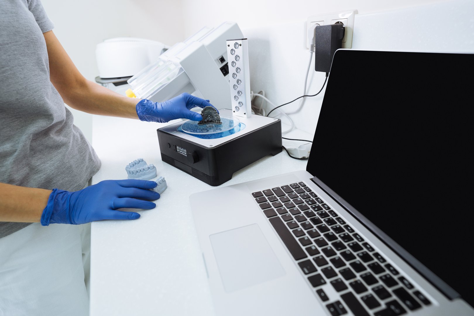 Dentist uses device for washing a dental 3d print in a cleaning solution, and curing the mold using UV light.
