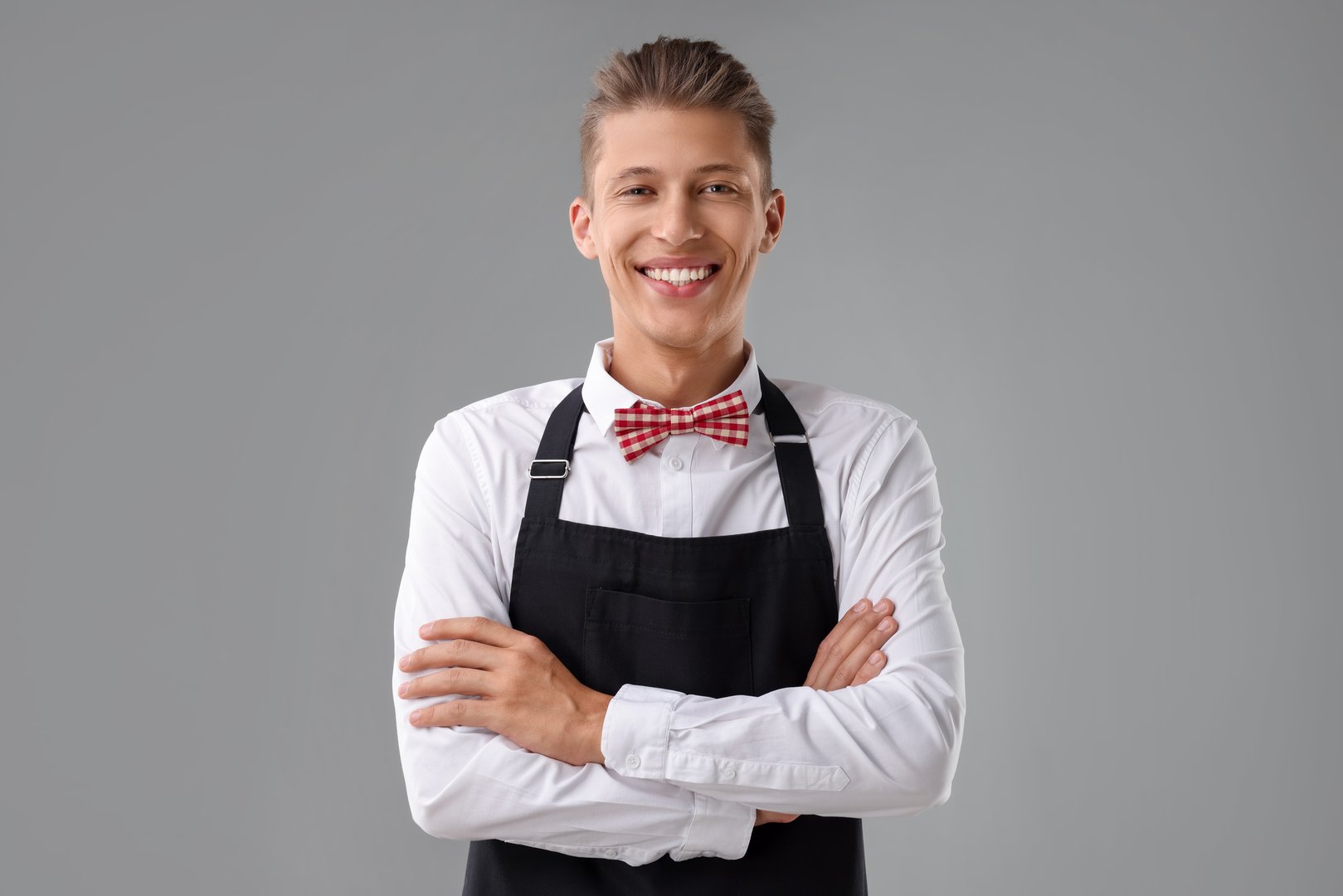 Portrait of smiling fast-food worker on gray background