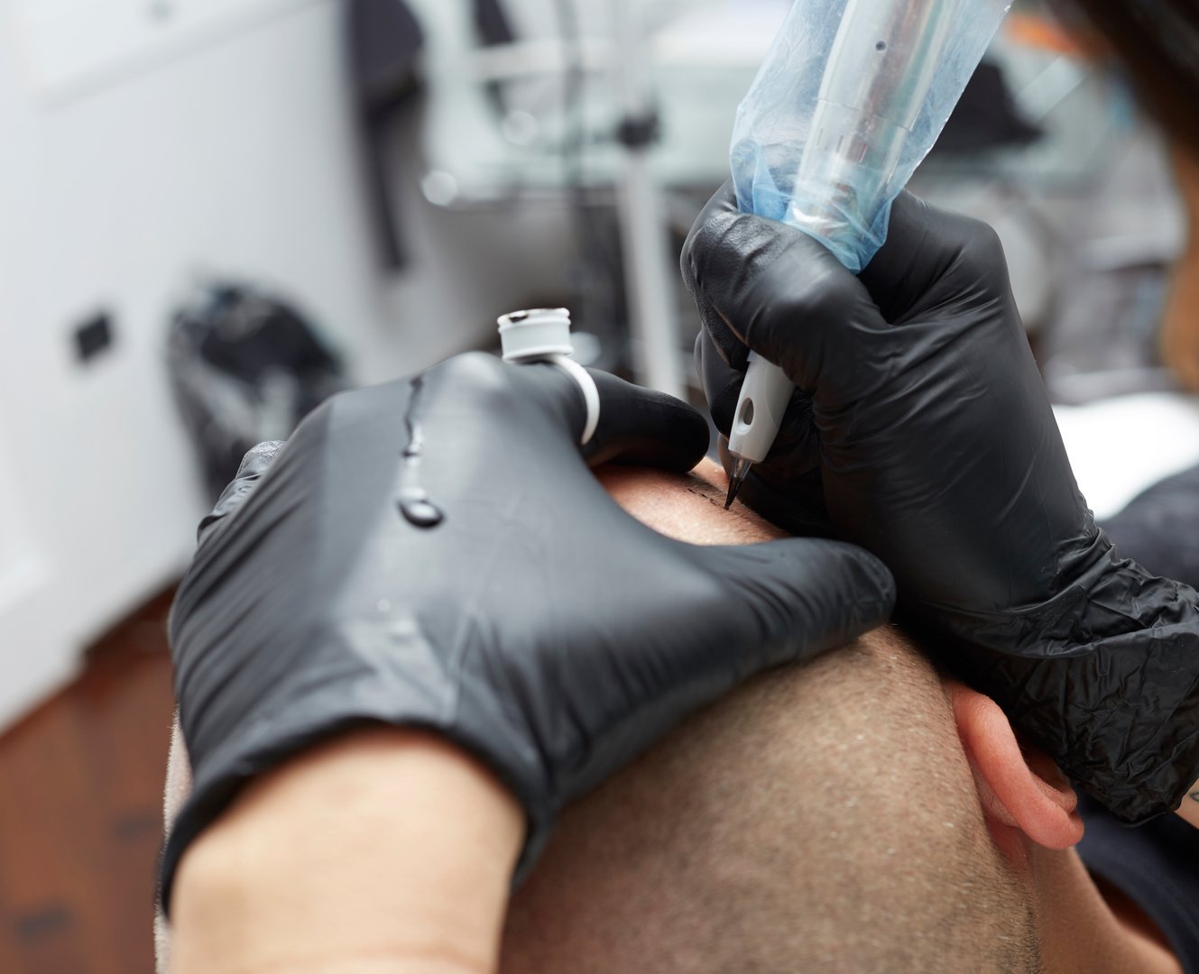 Cosmetologist making permanent makeup on man head - tricopigmentation