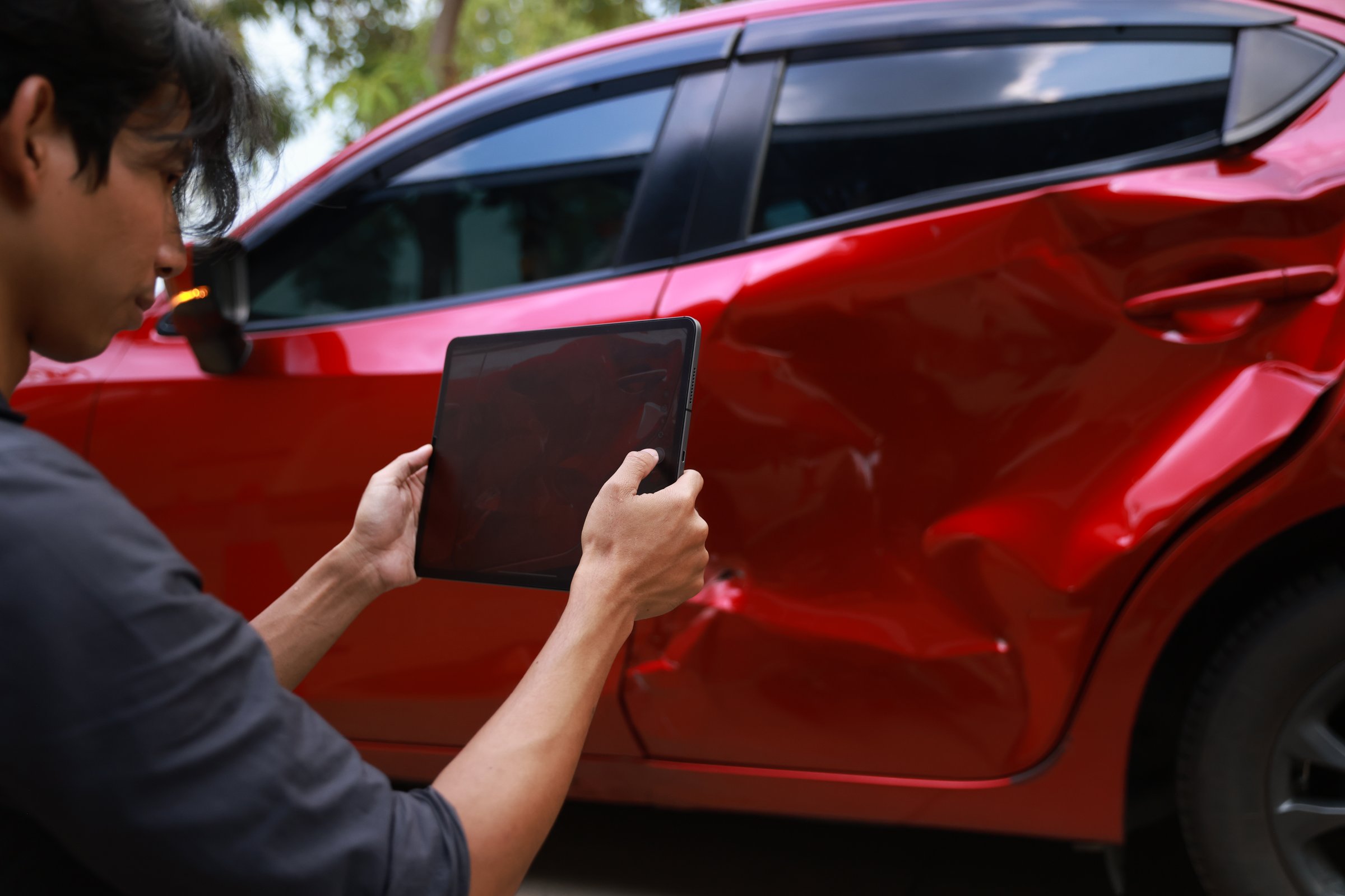 Drivers use mobile phones and tablets to take photos of car crashes for insurance claims due to road accidents. Drivers Involved In Car Accident Taking Pictures Of Damage And Calling Insurance Company