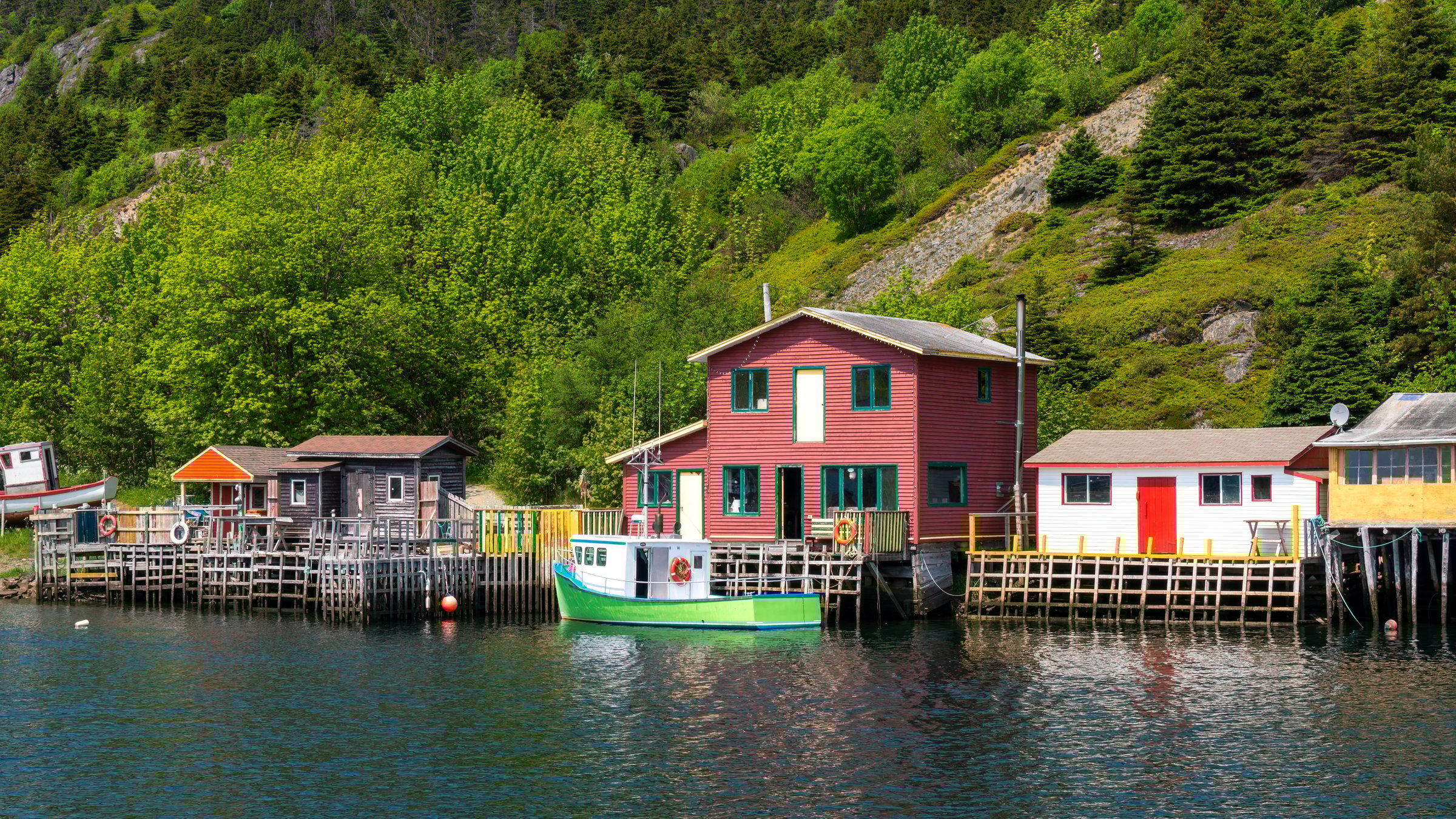 St. John's, Newfoundland, Canada - June 9, 2025: A historic fishing village where colourful houses and fishing stages line a narrow, sheltered harbour The Gut. Surrounded by rugged cliffs and Quidi Vidi lake.