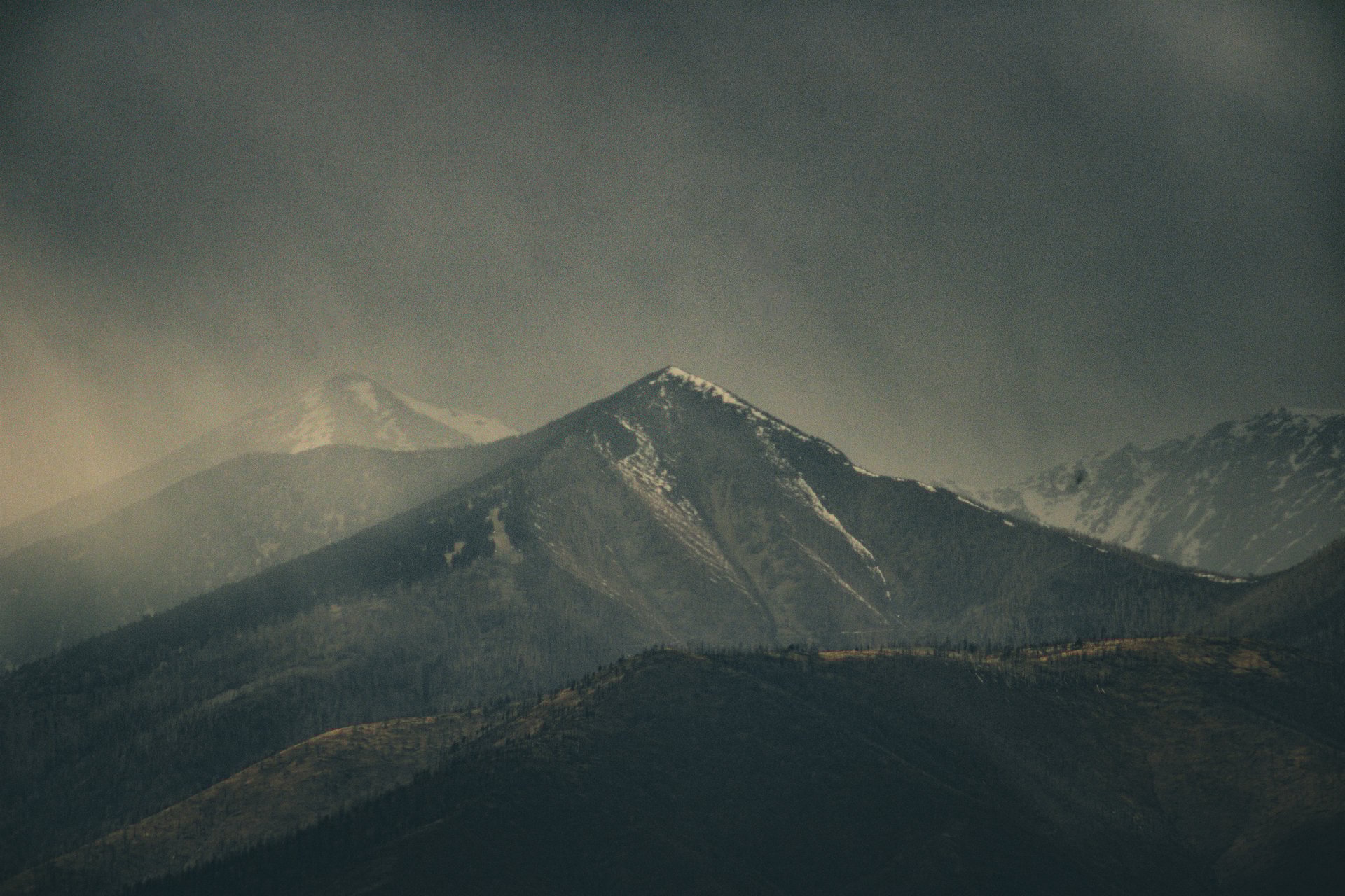 A dark, moody picture of the snow capped San Francisco Peaks on a snowy, rainy, stormy day just north of Flagstaff, Arizona.