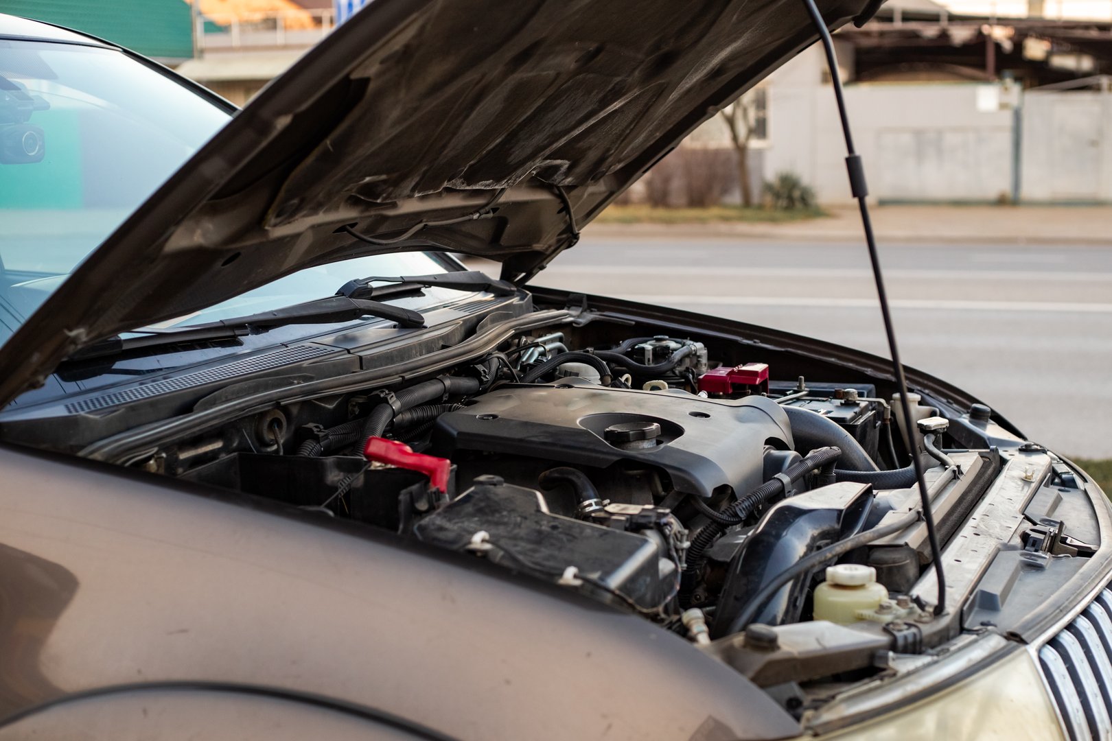 Car breakdown. The car is parked on the roadway with the hood open.