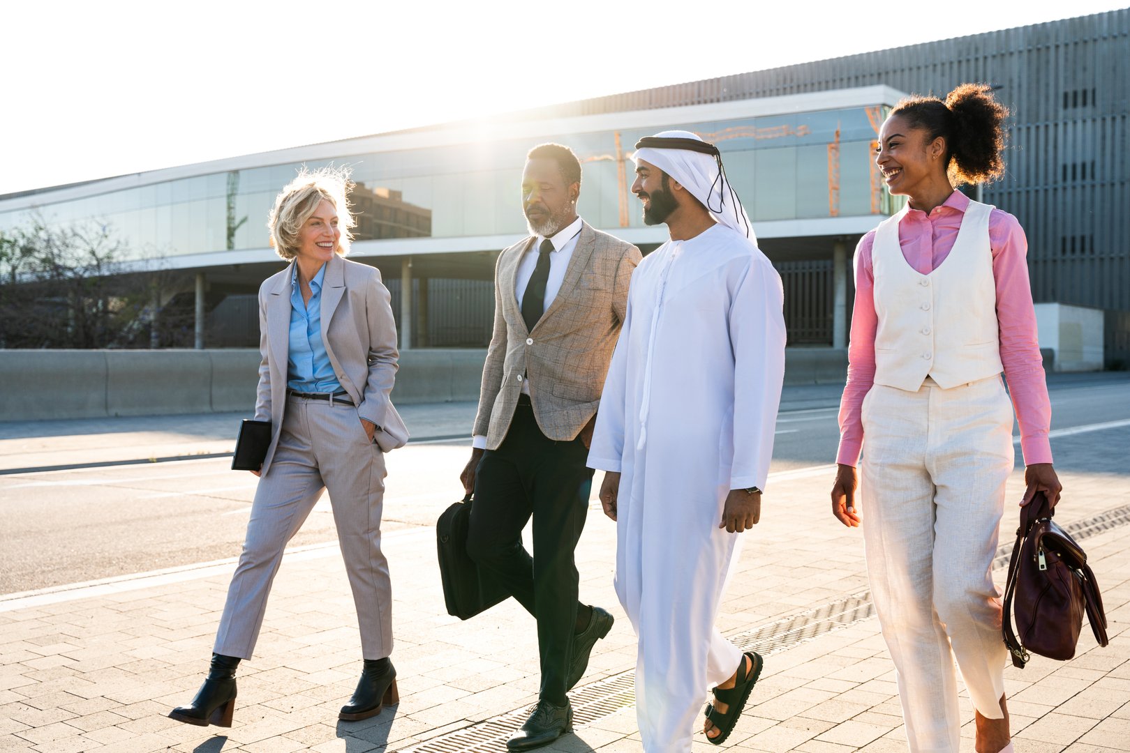Group of multiethnic business people meeting an emirati businessman - International corporate business team bonding outdoors in the city