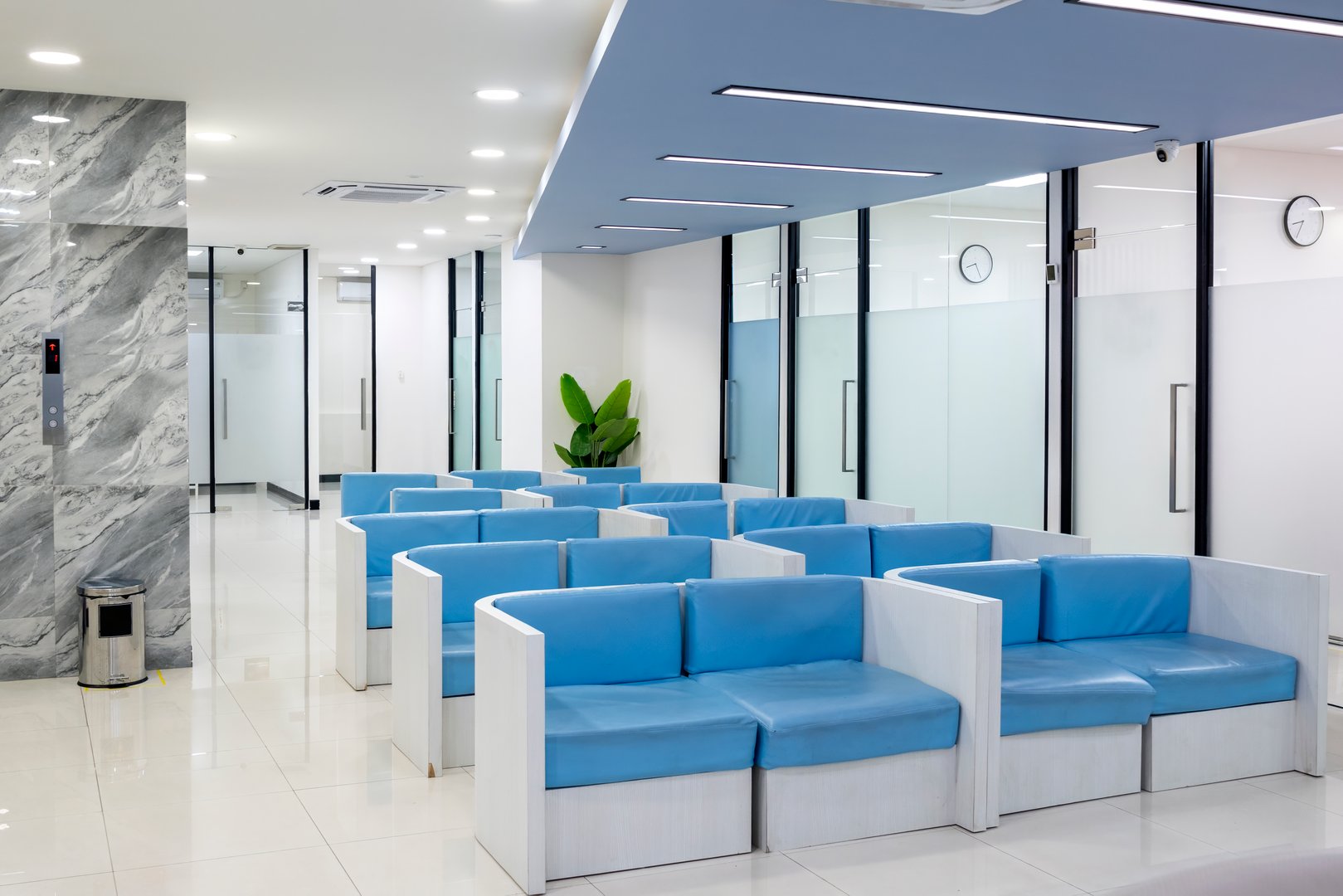 Row of comfortable couches in waiting room for patients with doctor appointments in a modern healthcare clinic or hospital