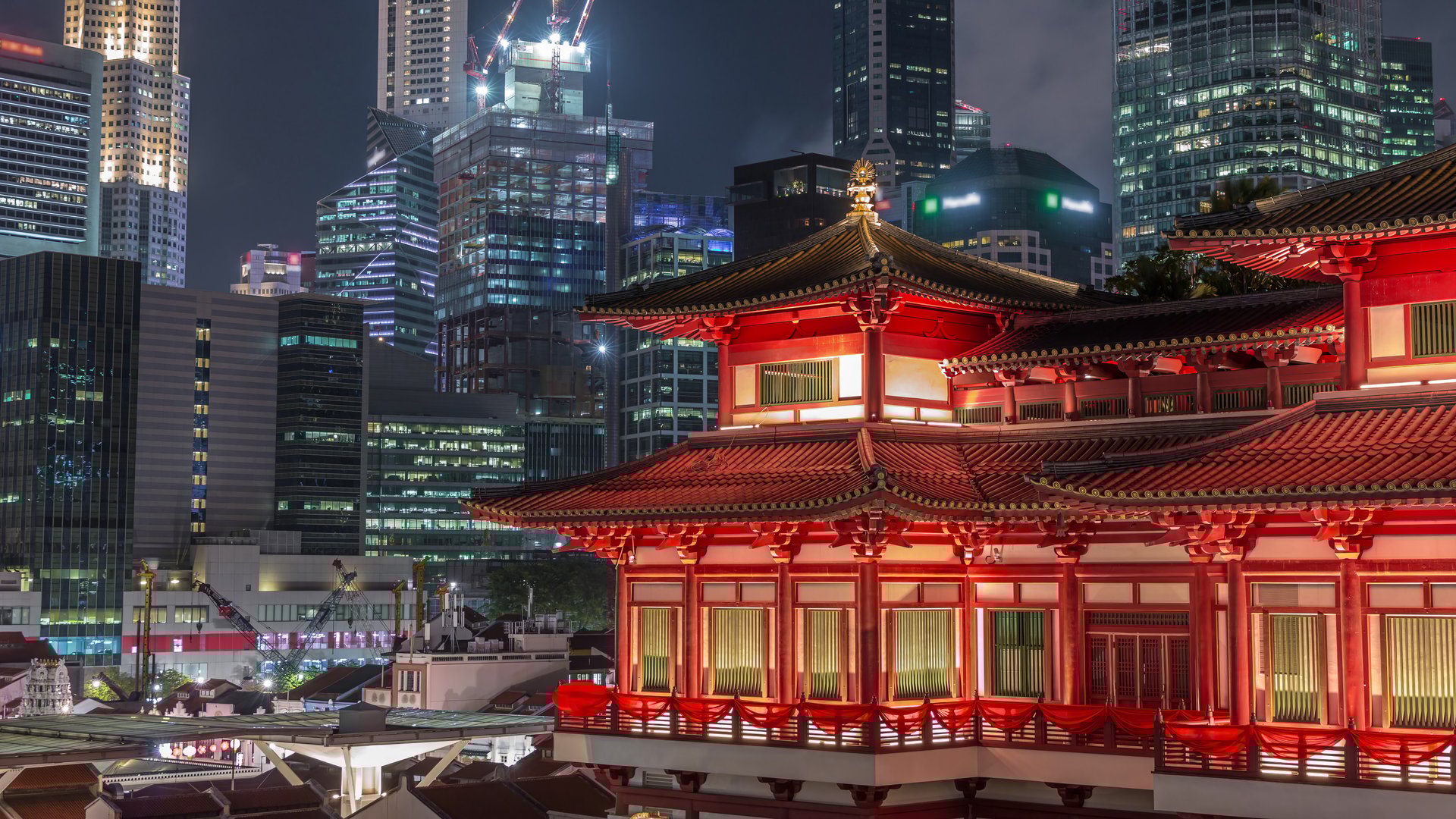 新加坡牛车水夜景，佛牙寺灯光璀璨，背景是城市天际线