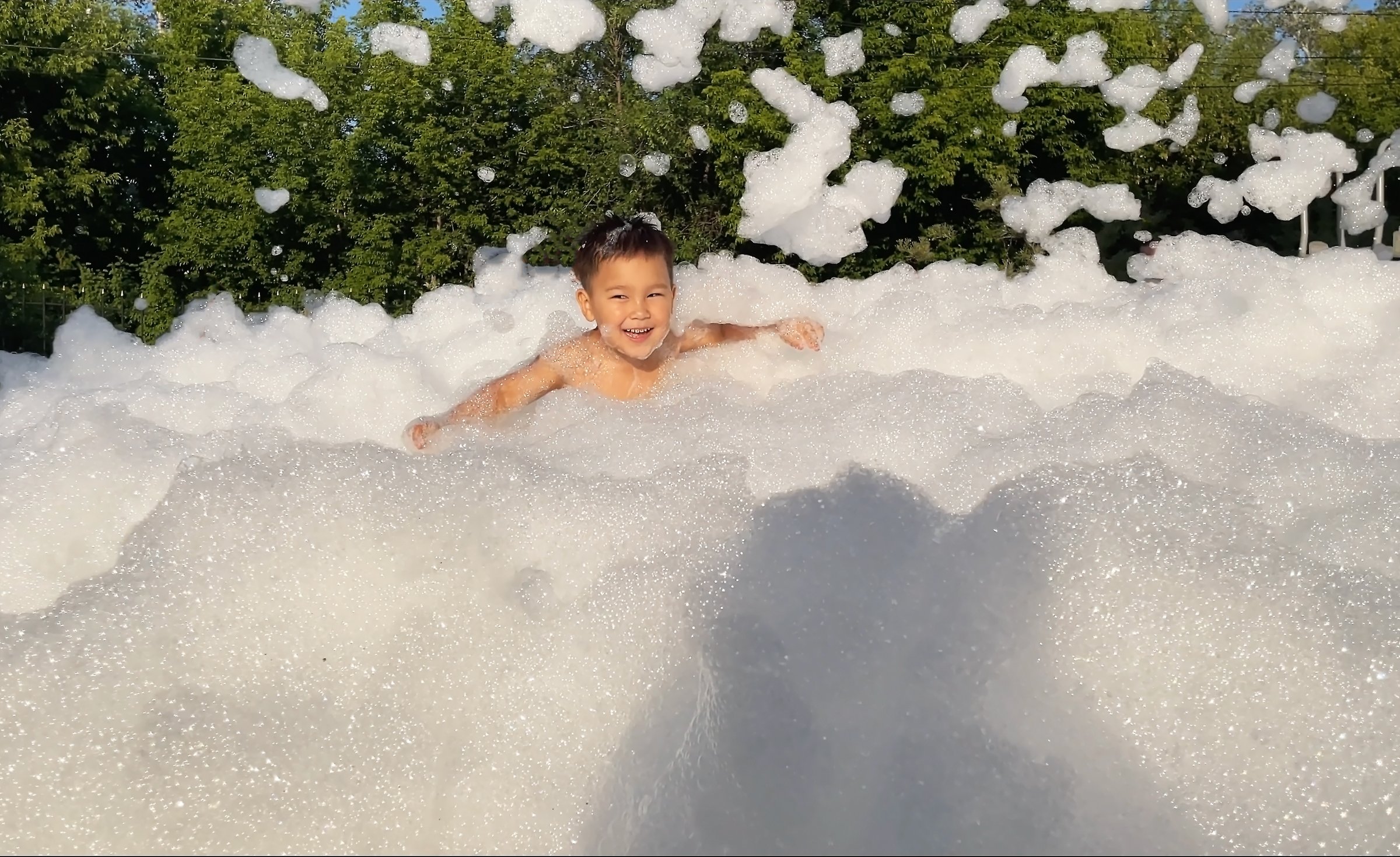 Foam party. Children have fun at birthday party outdoor in the yard