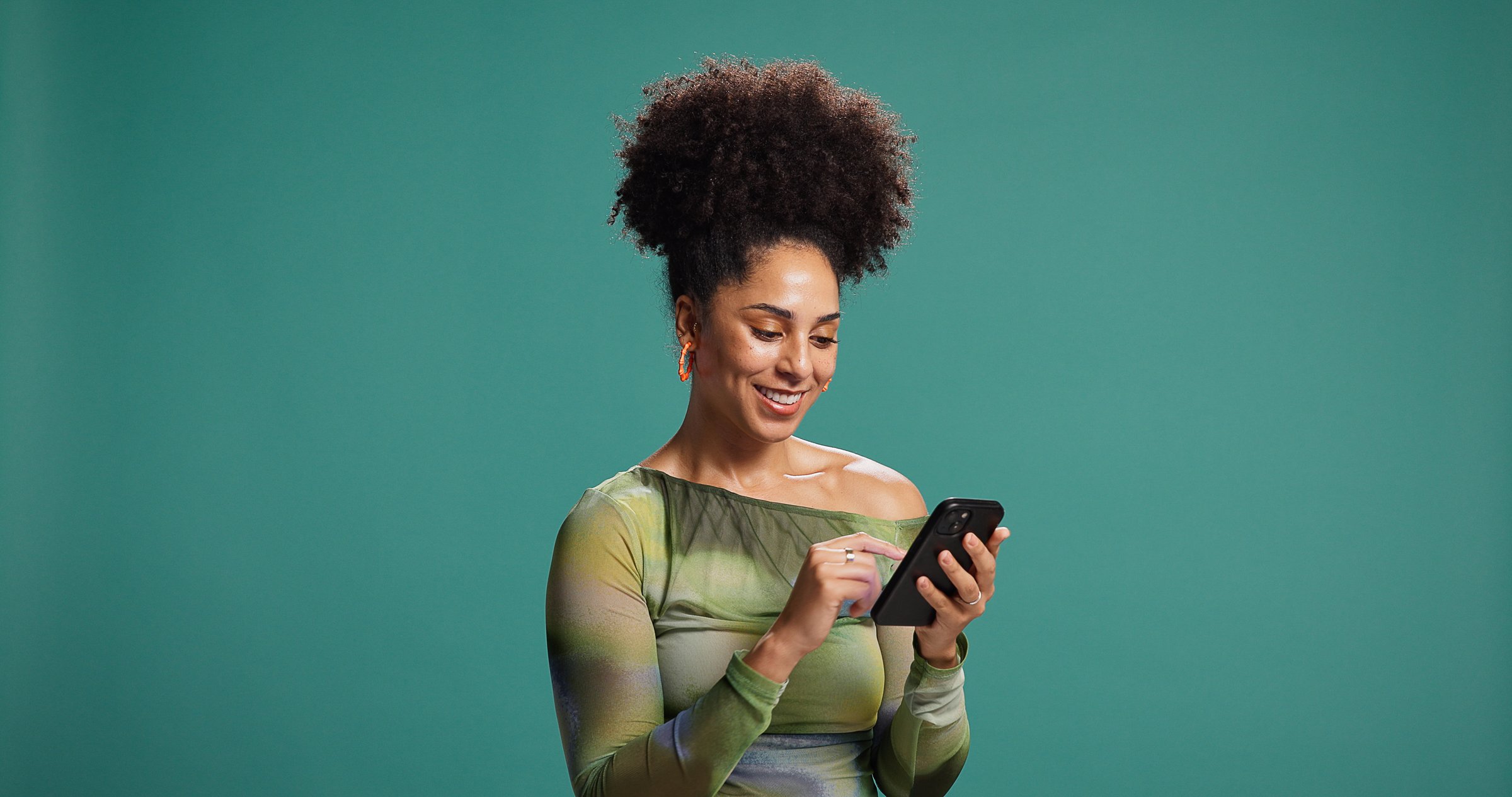 Phone, smile and woman in studio for social media, text or reading fashion blog. Mobile, online chat and happy African model on app for news, check forum and play game on background with mockup space