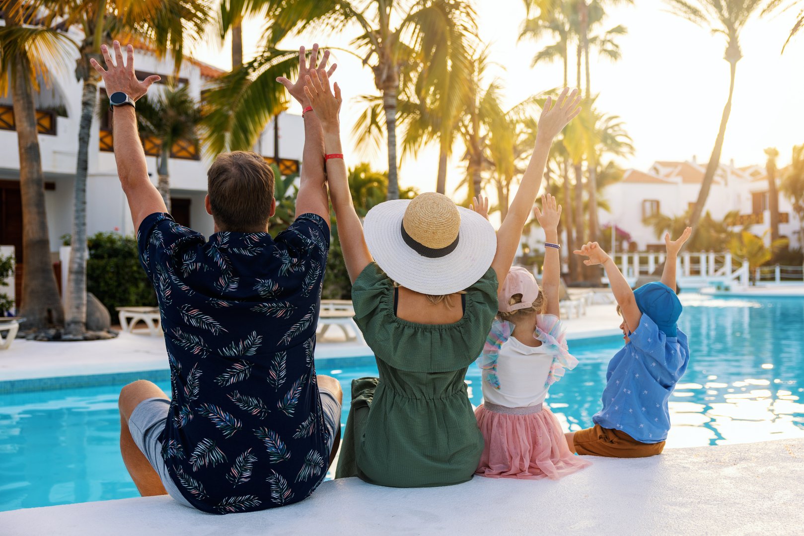 Familia feliz en piscina tropical