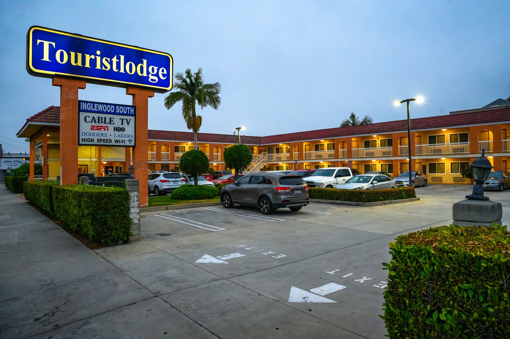 Inglewood, California, USA - June 4, 2023 : Evening view of Touristlodge with parking lot and signboard. Touristlodge is a hospitality company offering budget-friendly accommodation to travelers.