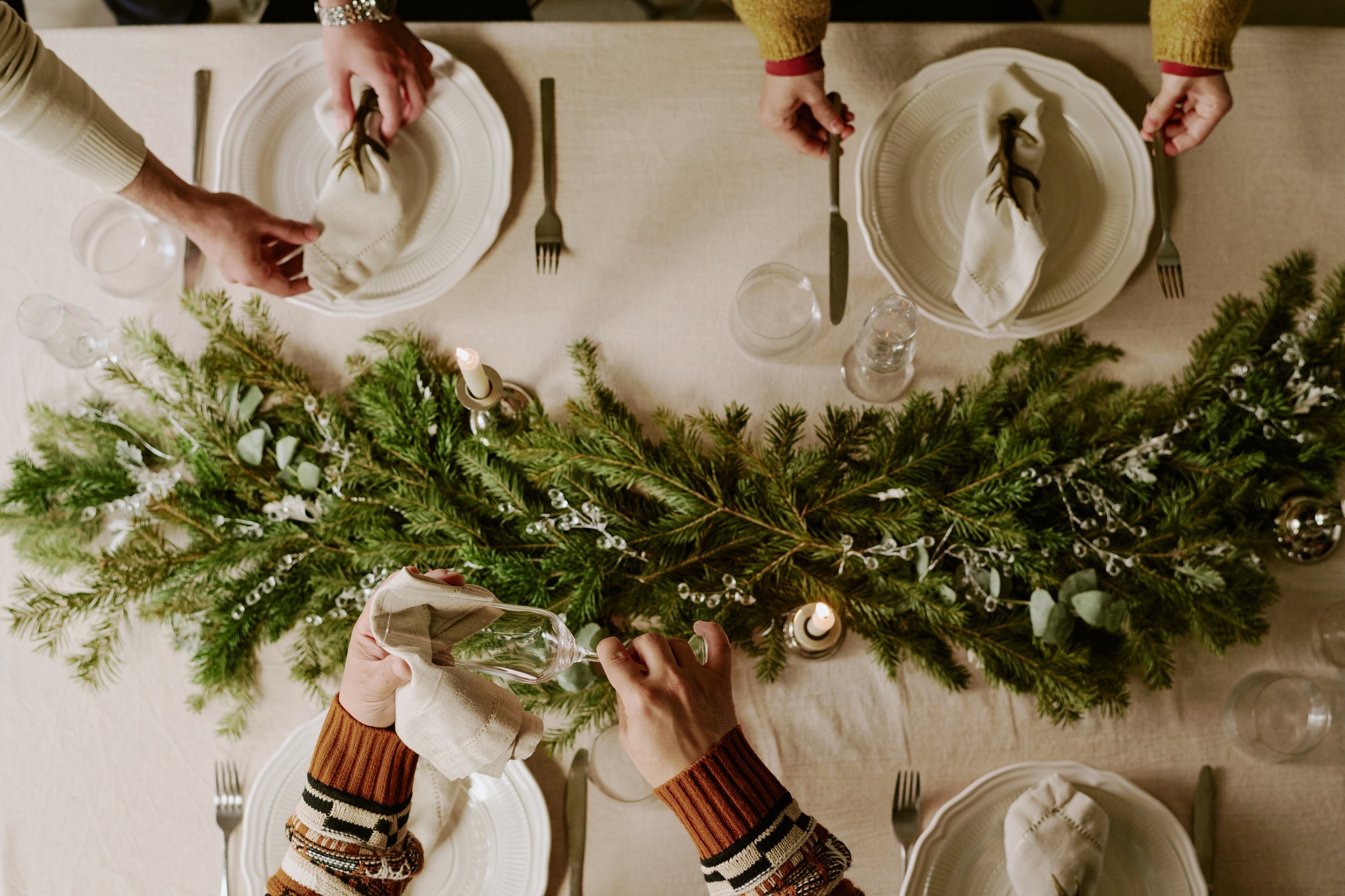 Top down shot of unrecognizable female and male hands polishing and serving table together to prepare for X-mas night