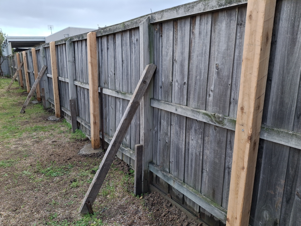 Timber fence with metal posts on hillside