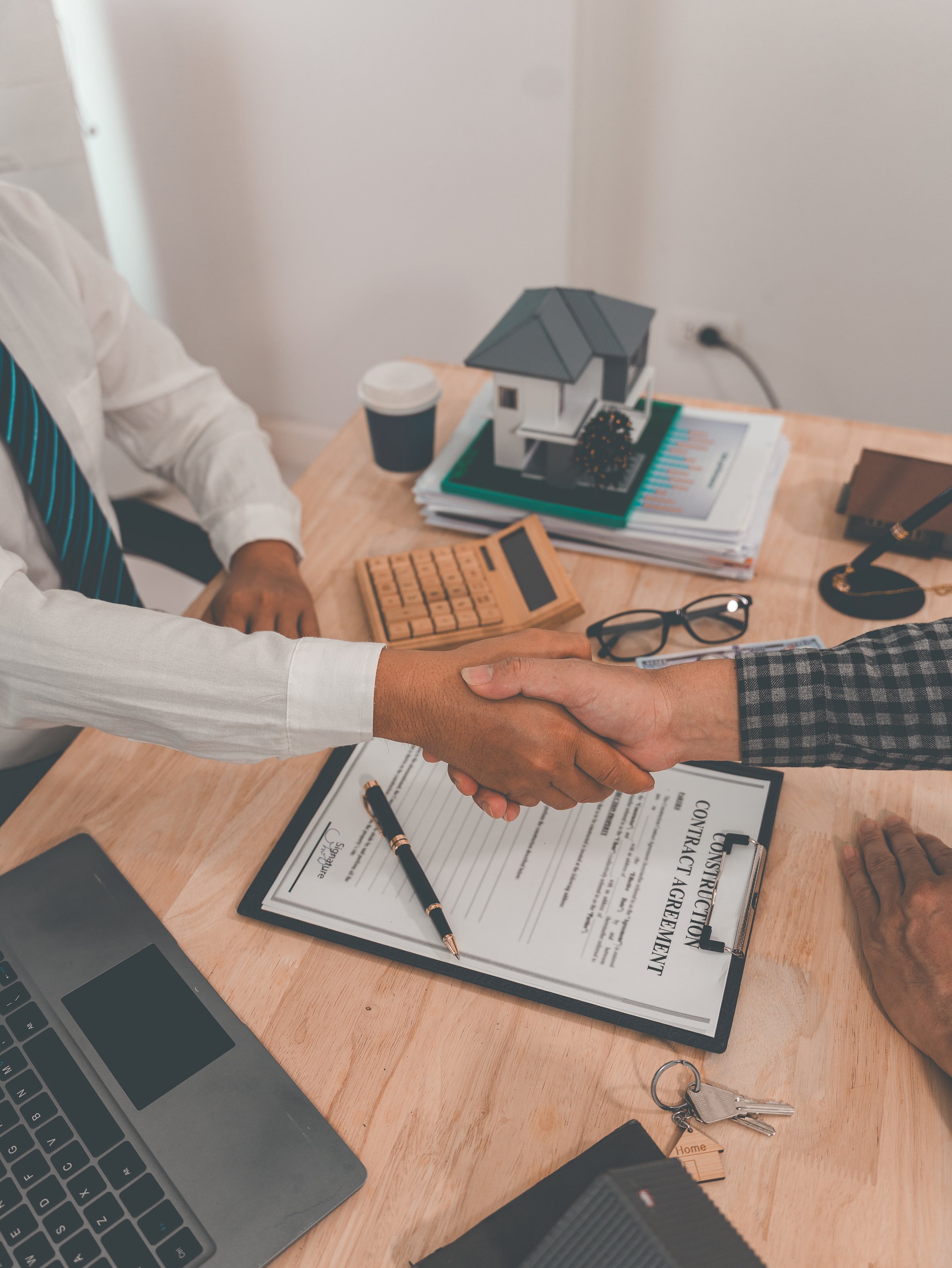 Real estate agent and client shake hands after completing a contract