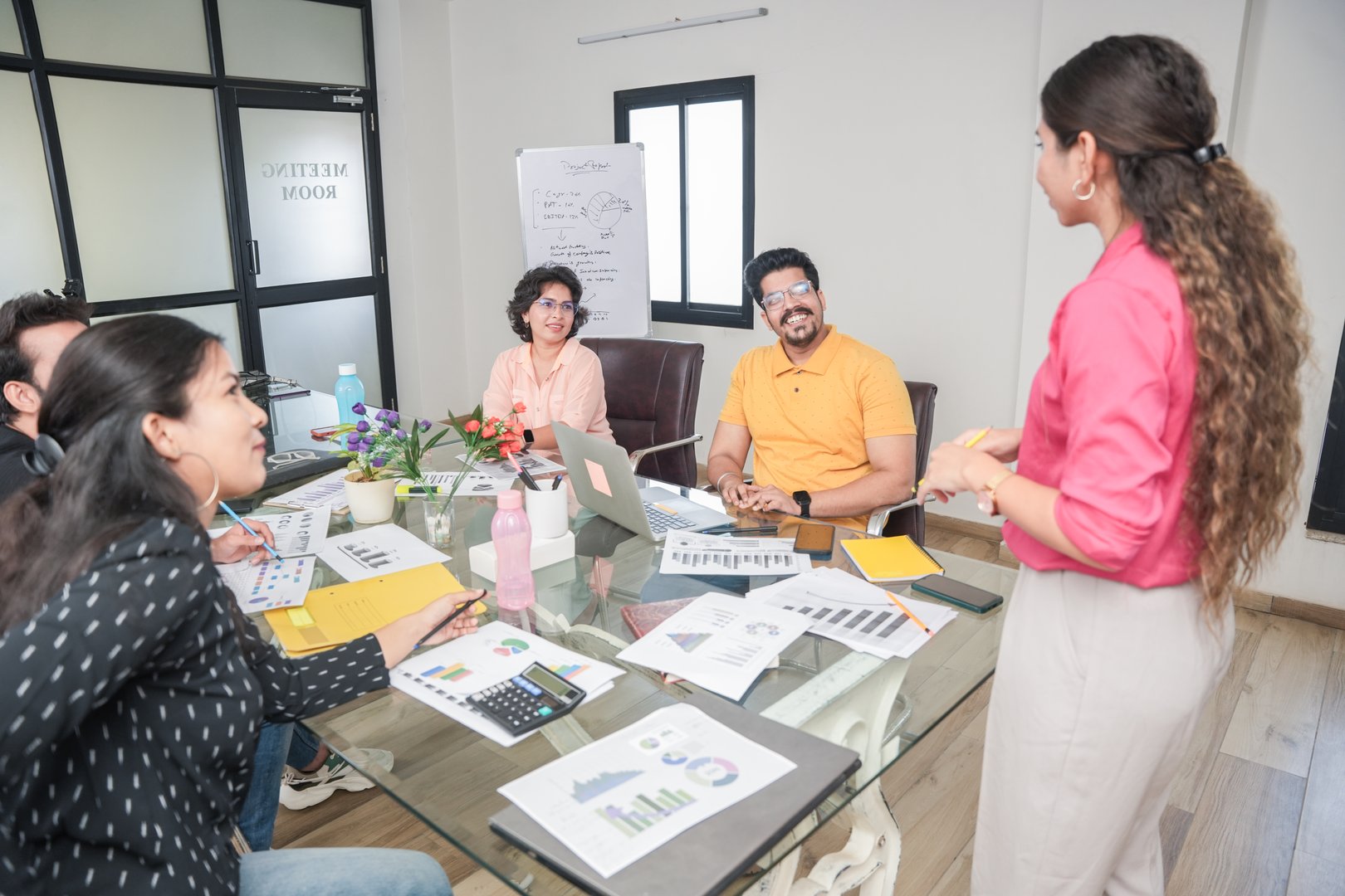 indian woman at office discussing about business project to team members or colleagues in meeting. Start up, leadership, presentation and workplace communication concept. Young Entrepreneur. teamwork