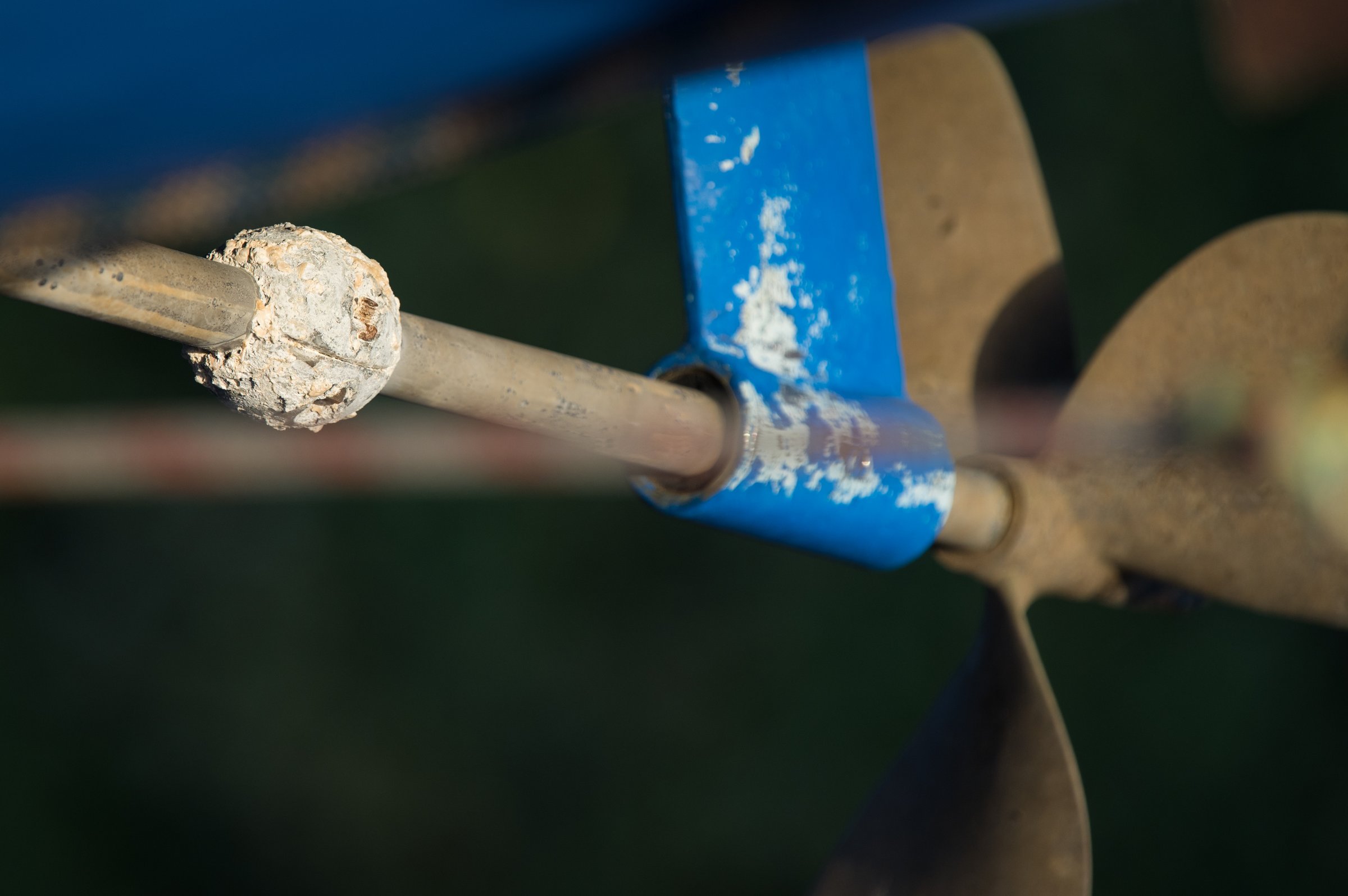Biddinghuizen, Netherlands - 10 14 2023: A round anode that is in an advanced state of corrosion on the propeller shaft of a steel sailing ship. The propeller is out of focus in the foreground.