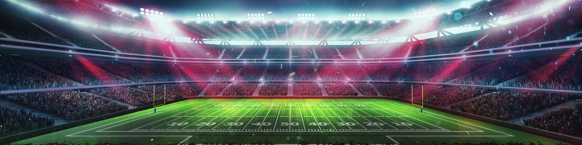 Wide angle view of American football stadium with brightly lit red lights, packed crowd, and football field with yard lines and goal post. Concept of sport, tournament, championship, game, event