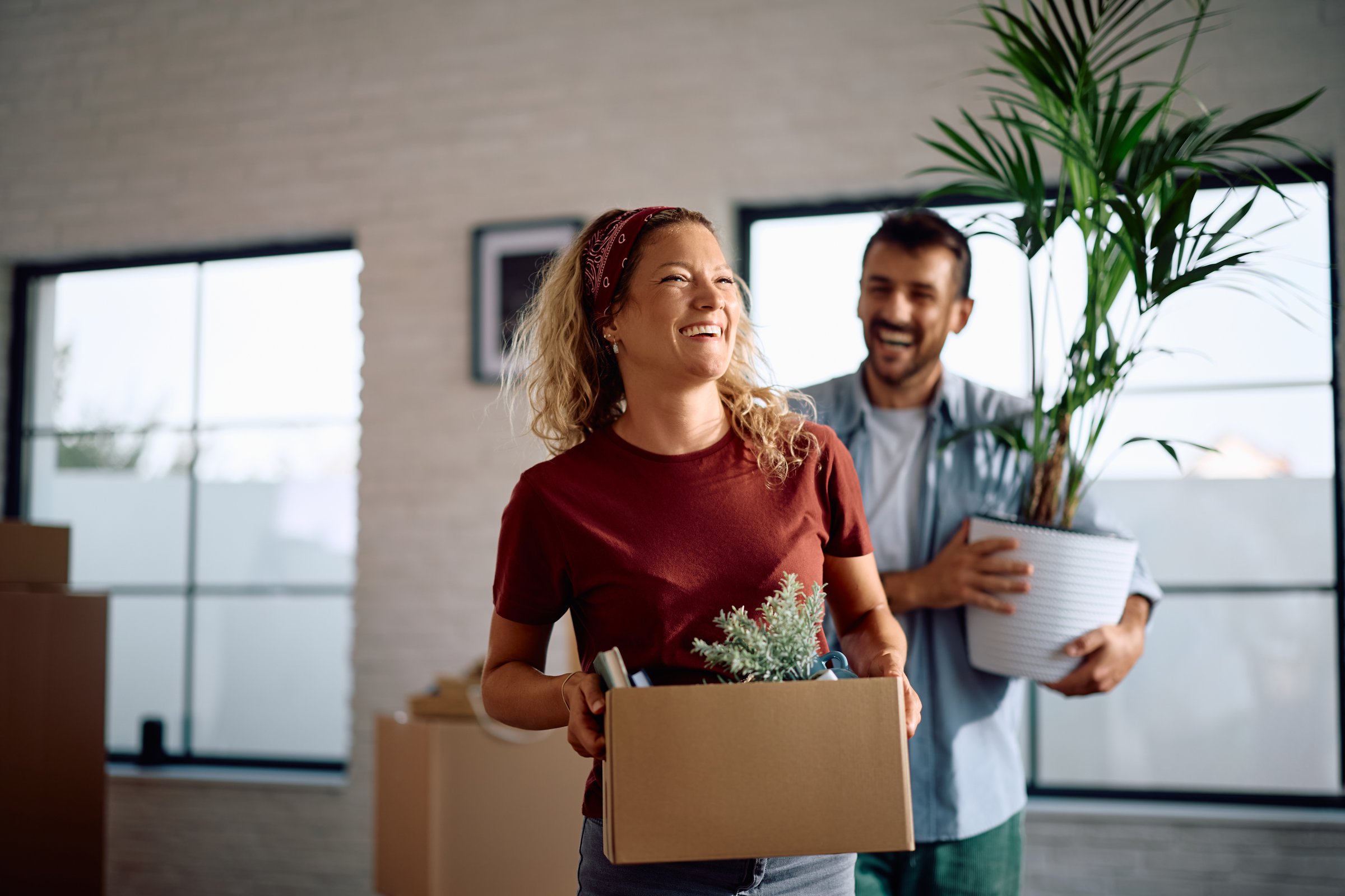 Happy couple bringing their belongings into new home. Copy space.