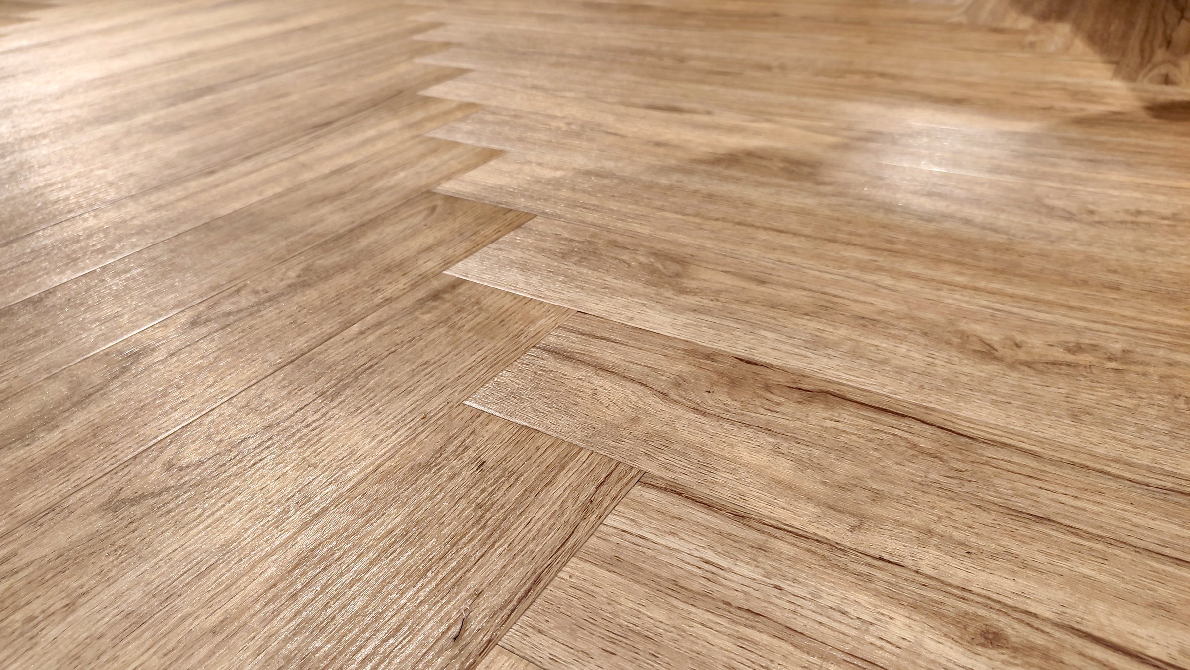 Close-up of a wooden floor, laid in a herringbone pattern