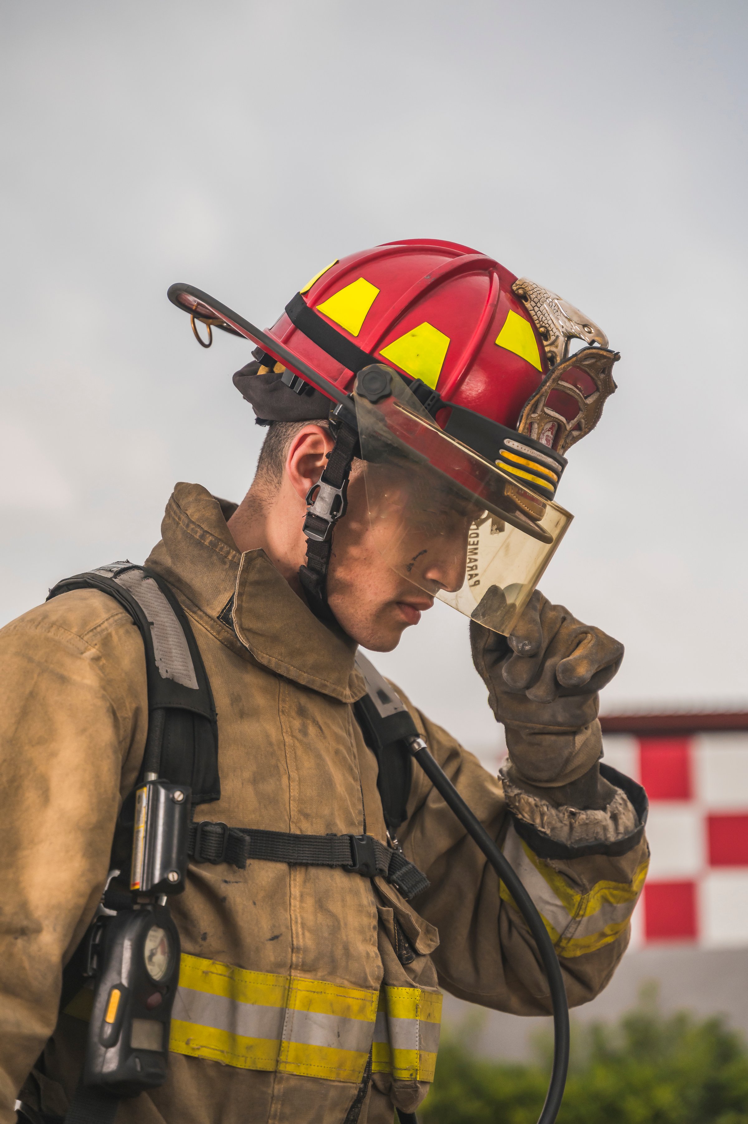Brave firefighter putting on his air tank gear and other equipment