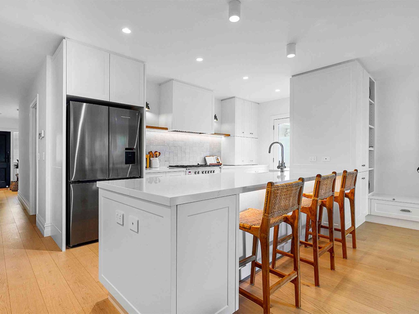Green kitchen with white countertops and hanging plants