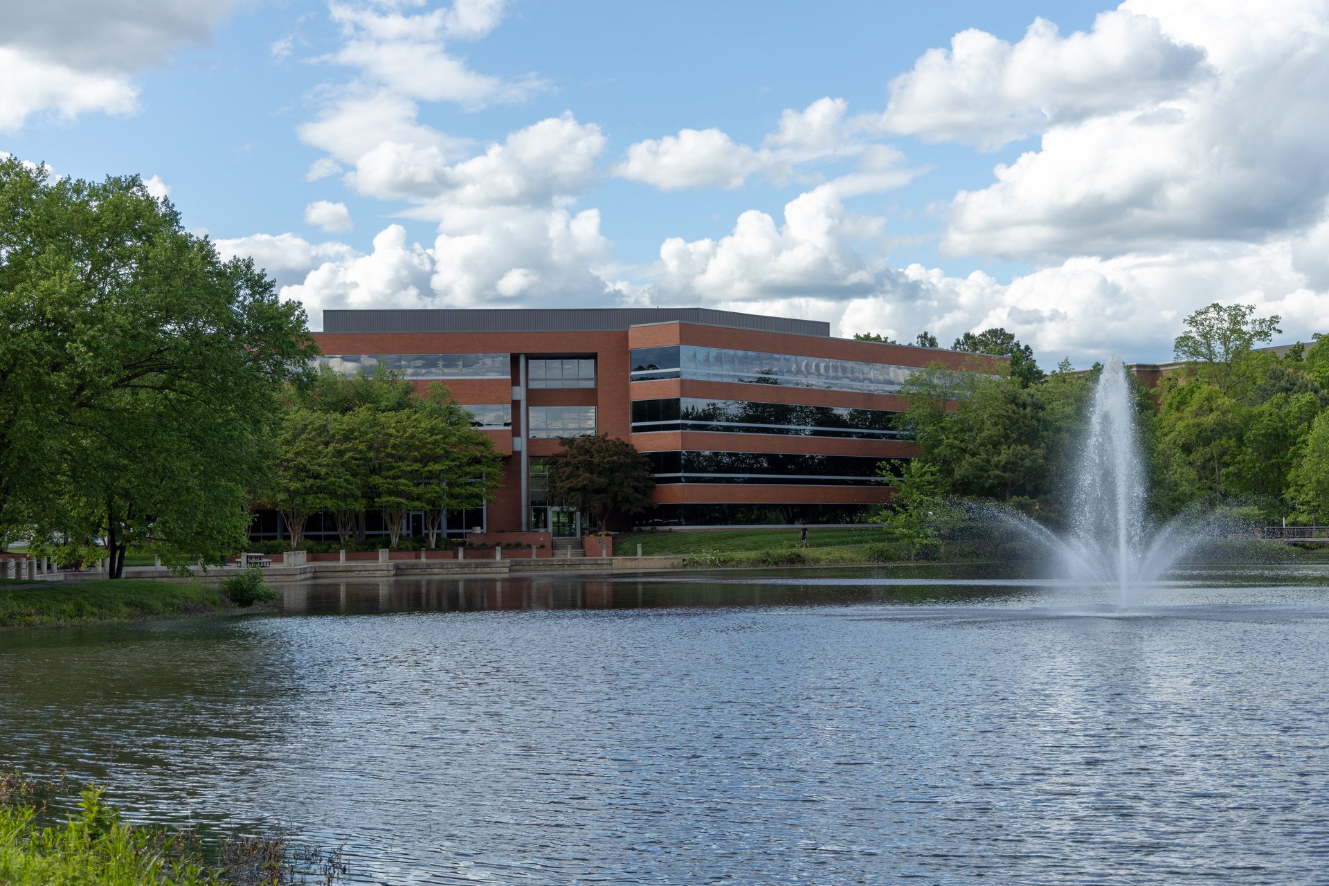 This is a view of a modern office building that is located in the United States as seen from across a pond.