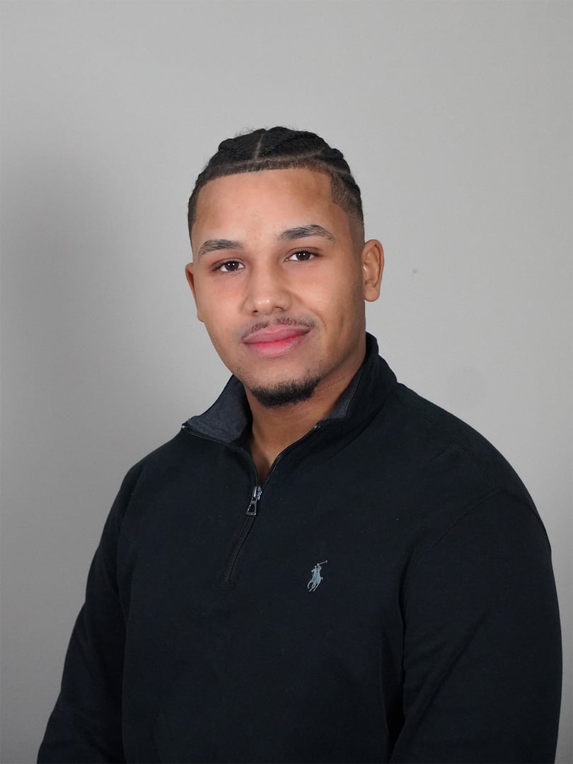 Two business colleagues are standing on a balcony, having a conversation about work while holding a tablet and a coffee cup