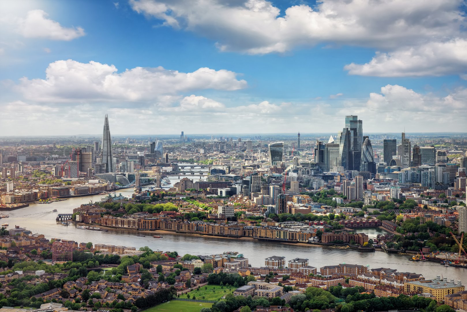 Elevated panorama of the London skyline along the river Thames from London Bridge until the City during a sunny summer day, United Kingdom
