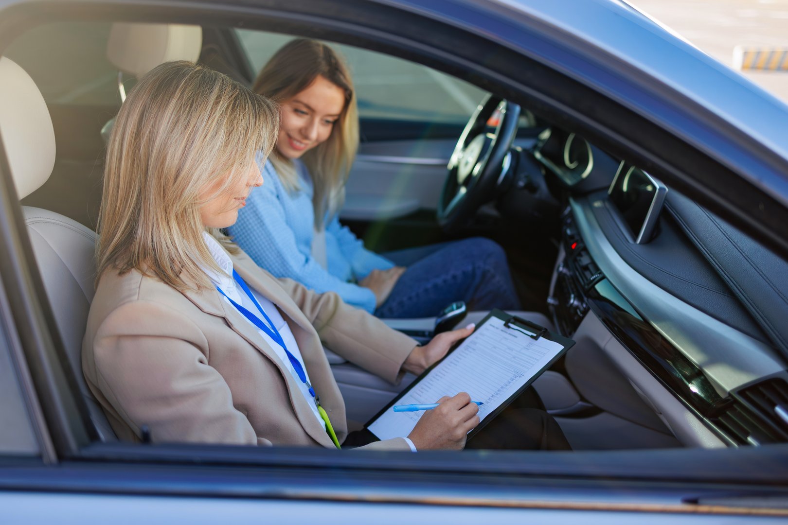Driving Instructor Evaluating Student Driver Inside Car
