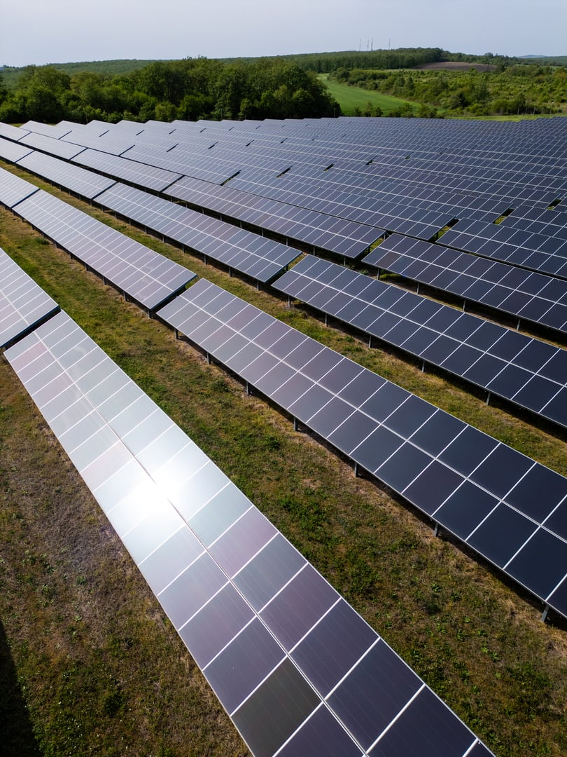 drone view of a solar power station next to a forest during summer. Renewable energy meets nature in action.