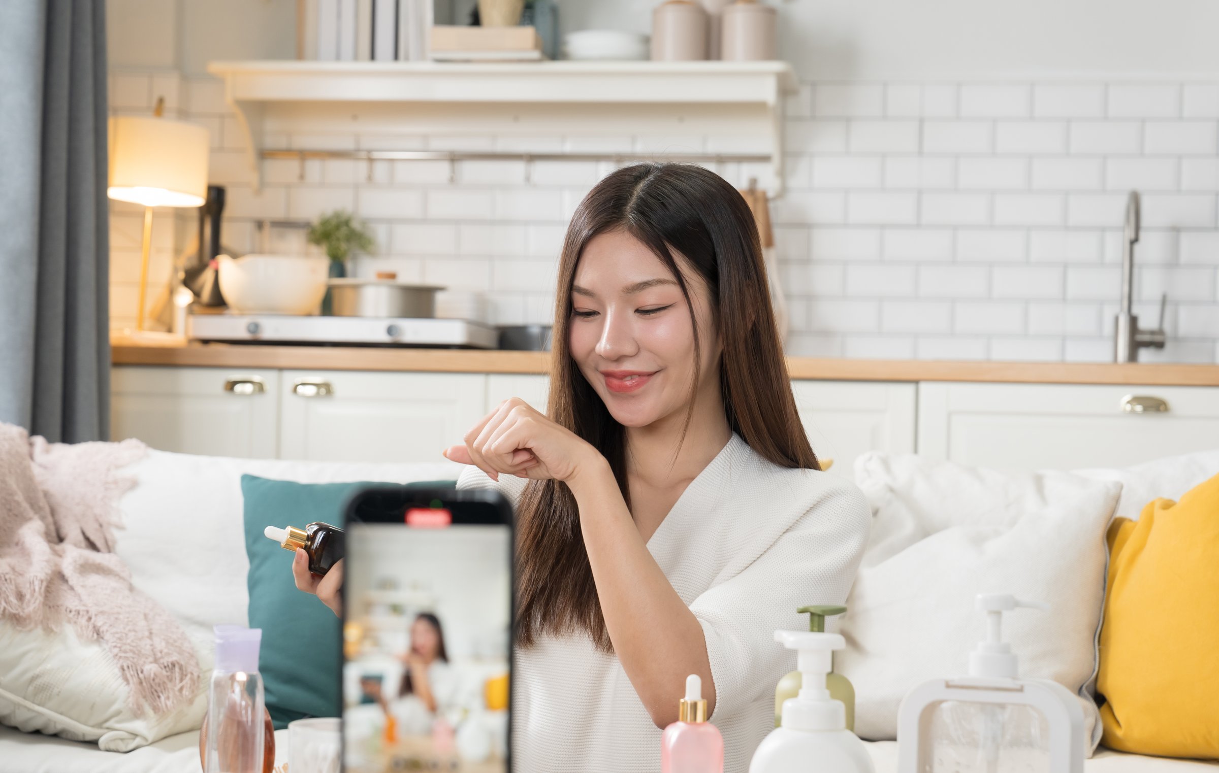 Asian beauty influencer live-streams and reviews cosmetics for her online audience.